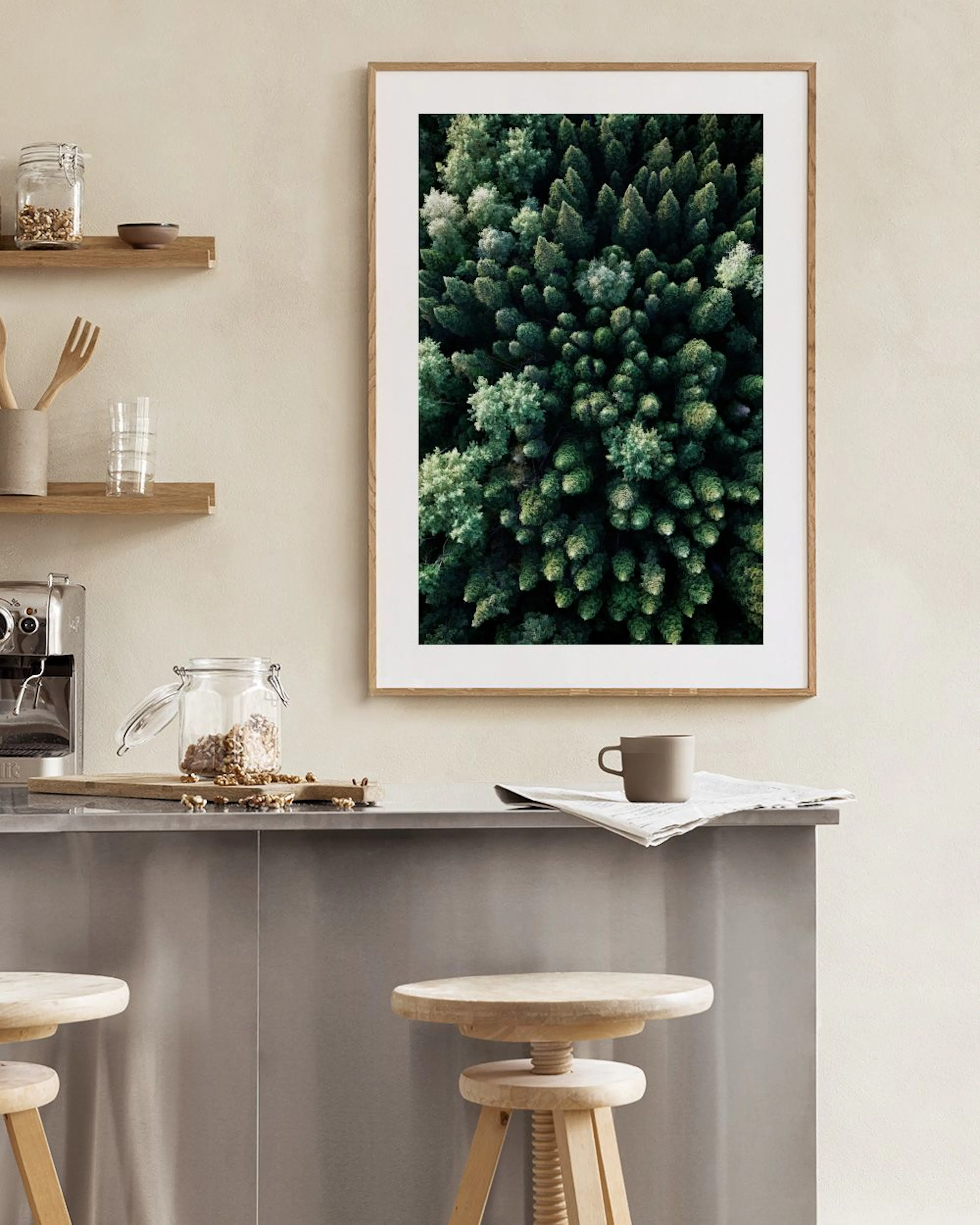 Póster de vista aérea de un denso bosque de pinos verdes colgando sobre un mueble blanco en una sala.