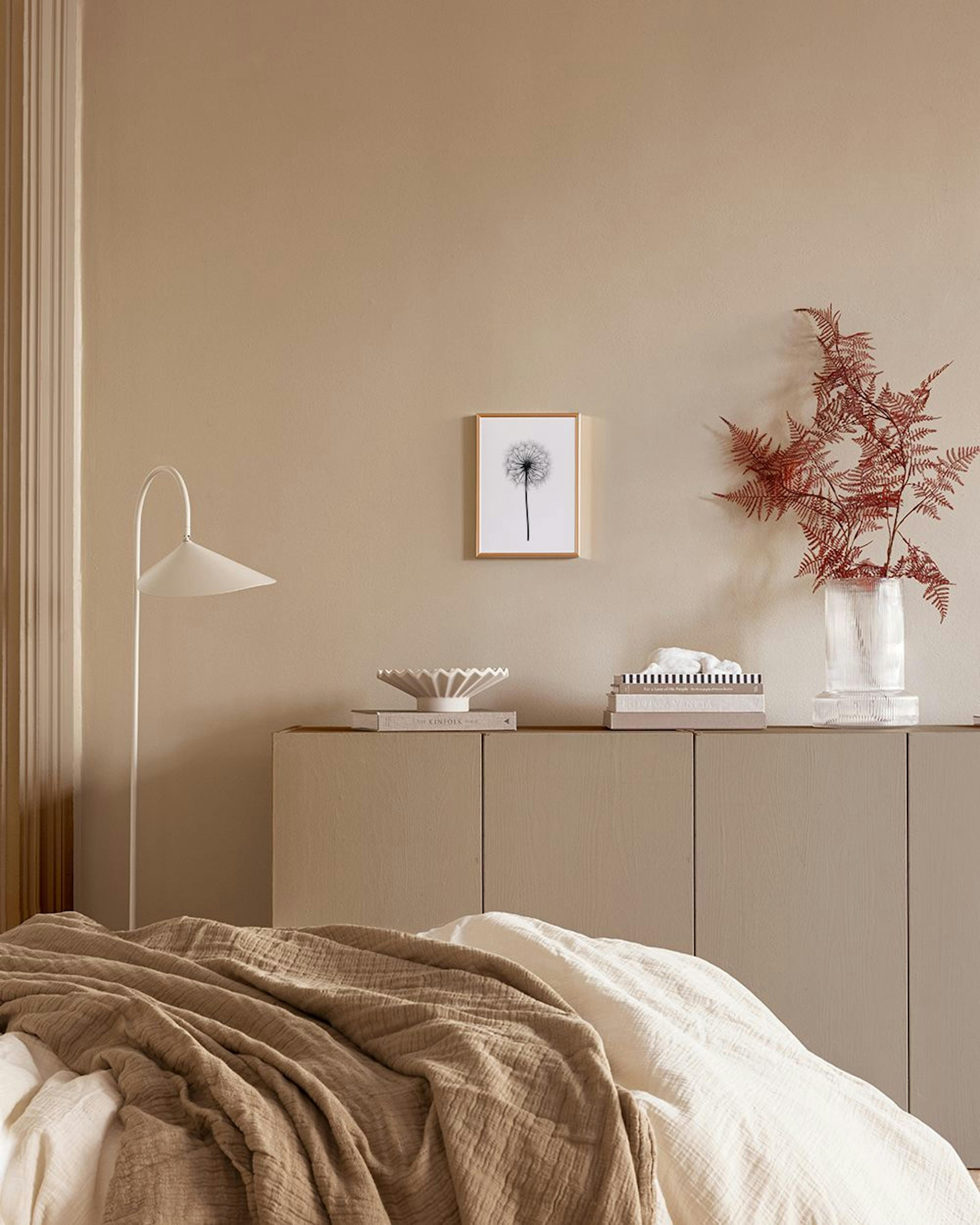 Poster van een zwarte paardenbloem tegen een witte achtergrond, hangend boven een rij witte vazen in een kamer met donkerblauwe 