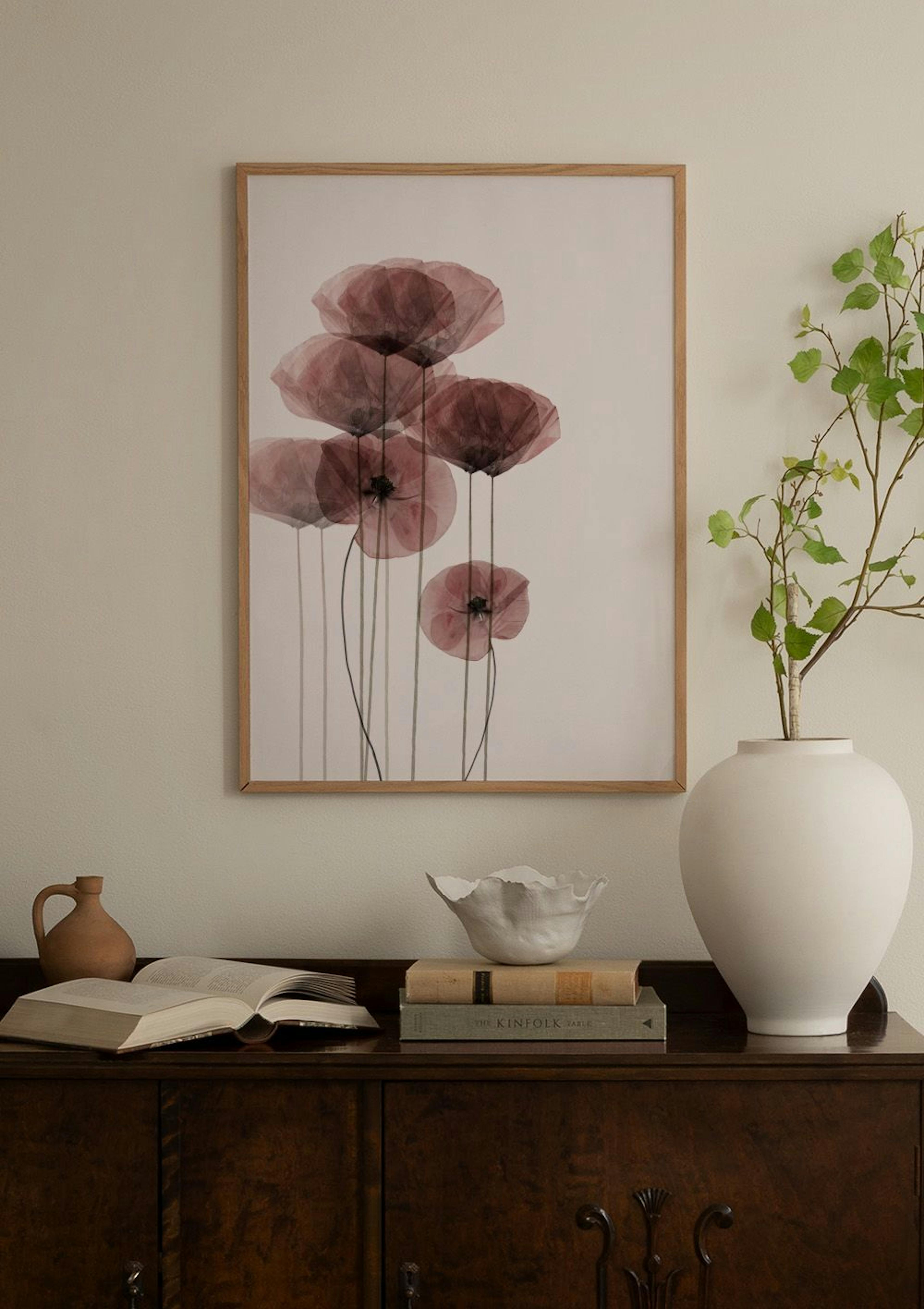 Um poster com formas orgânicas rosa, amarelo e preto com padrão tipo terrazzo, exposto numa parede de quadros acima de um sofá b