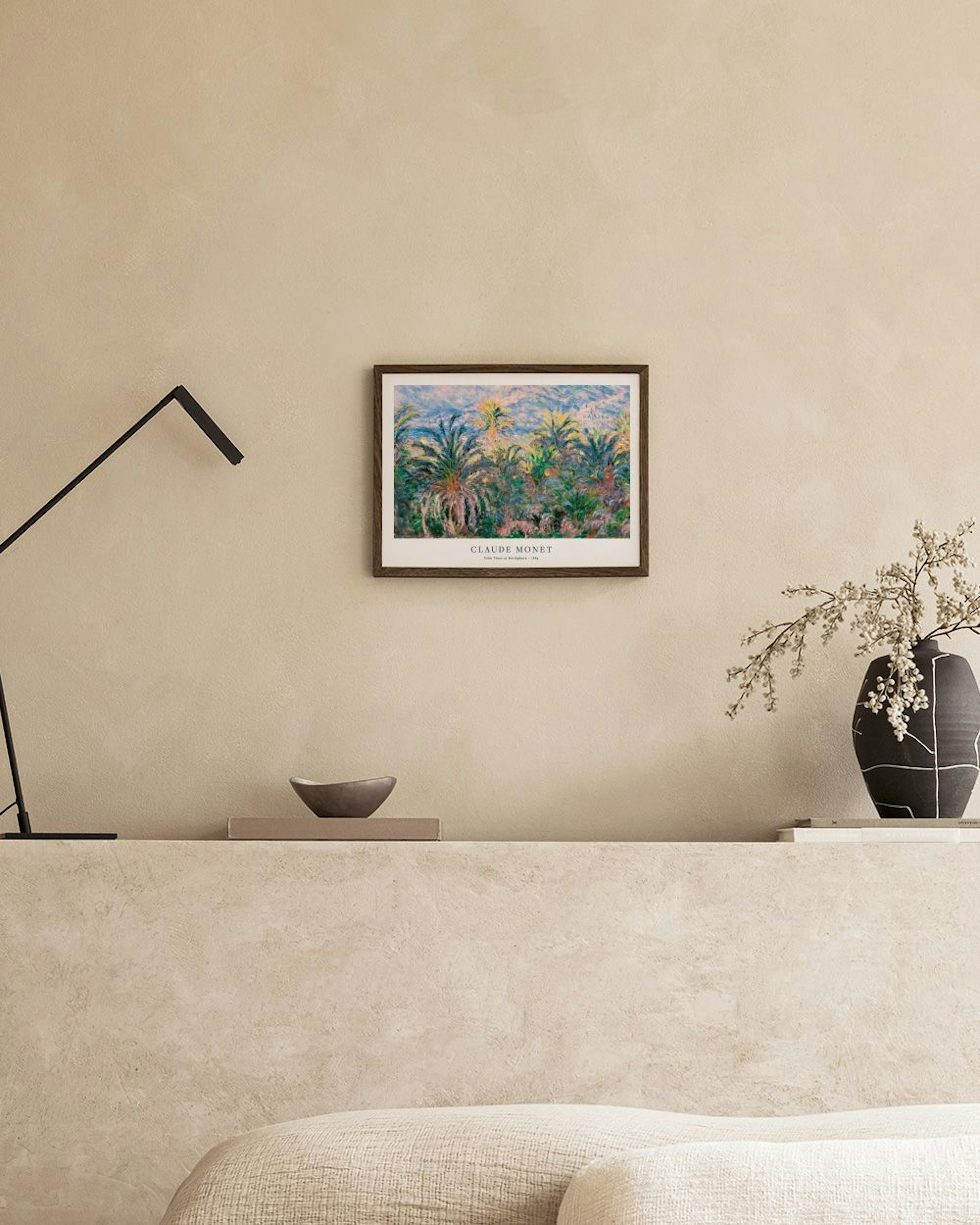 Claude Monets palm trees in a garden print, hanging above a white cabinet with a glass vase and books.