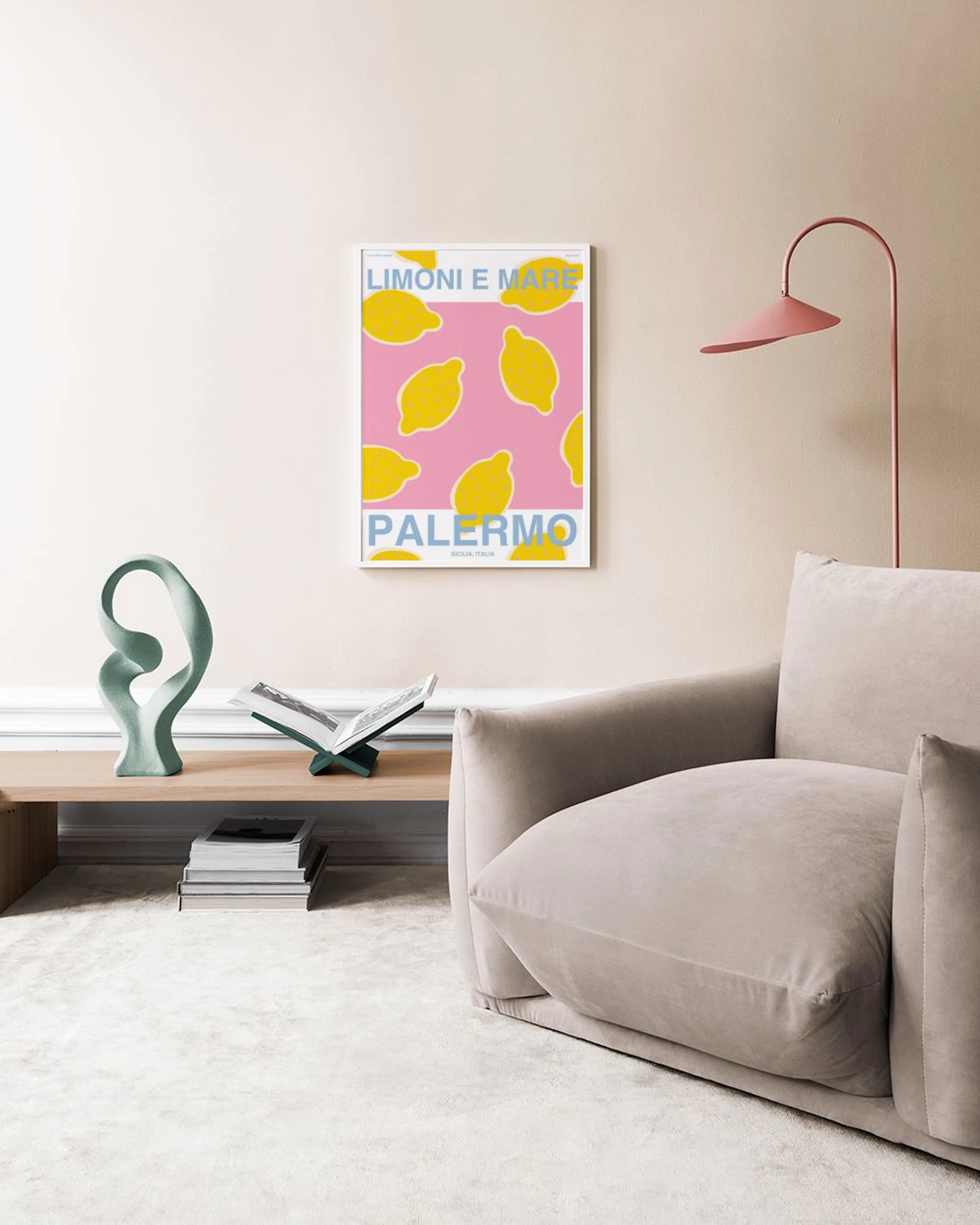 Plakat med gule sitroner på rosa bakgrunn, teksten Limoni e Mare Palermo i blått, henger over et marmorbord med vaser.