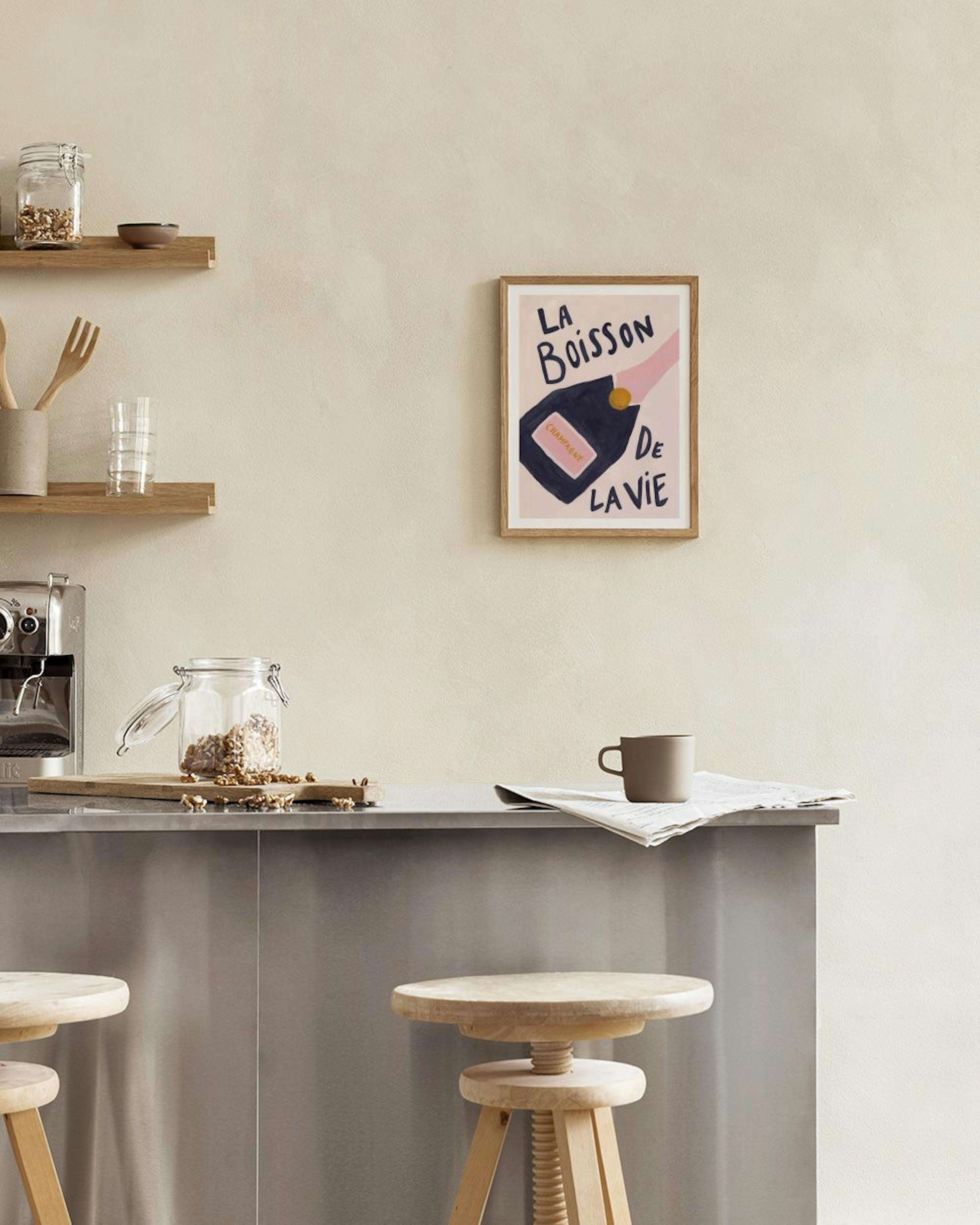A champagne bottle print with La Boisson de la Vie text, displayed above a white marble table with vases and books.