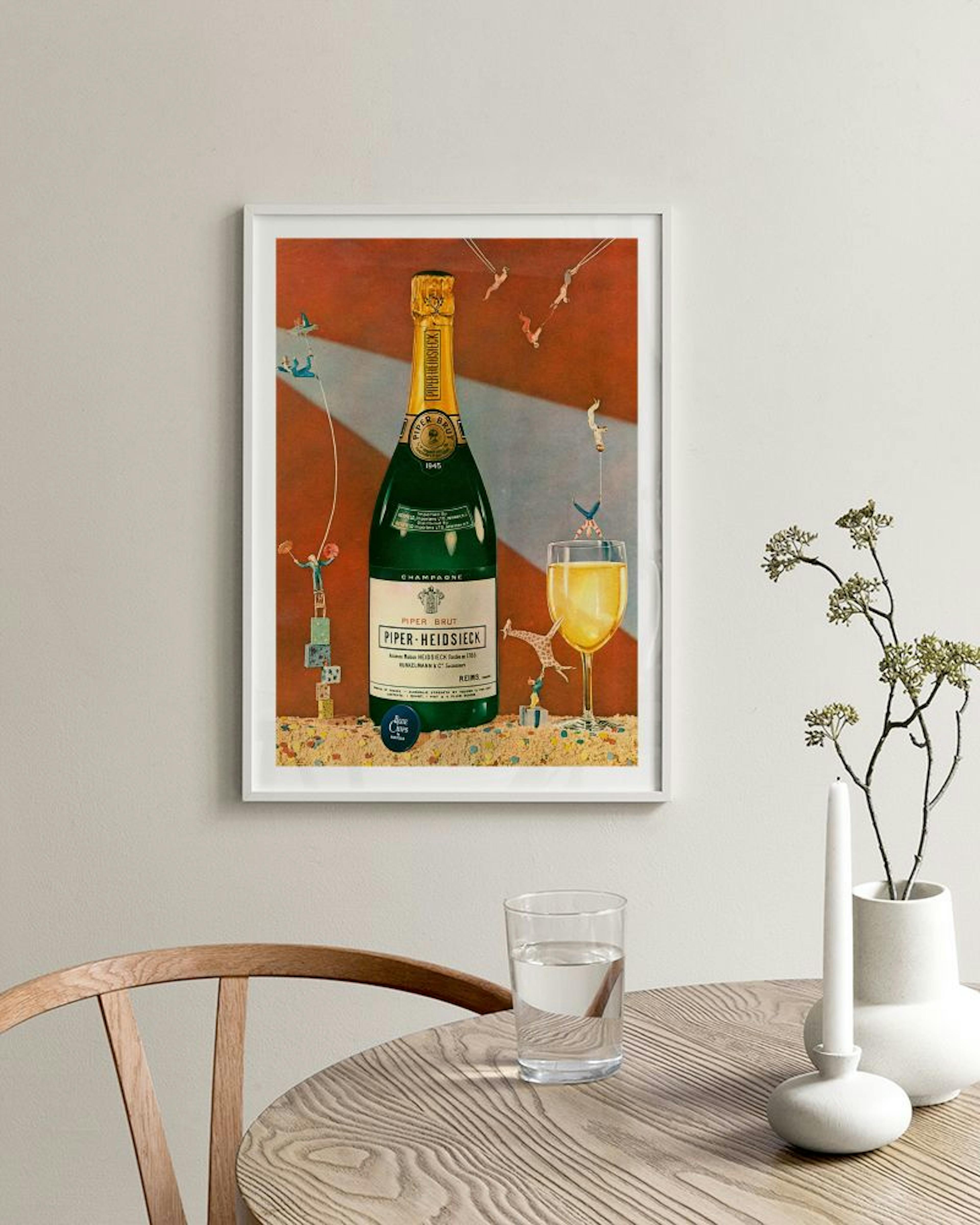 Póster de una botella de champán Piper-Heidsieck y una copa, con figuras pequeñas, colgado en una pared clara sobre un sillón y 