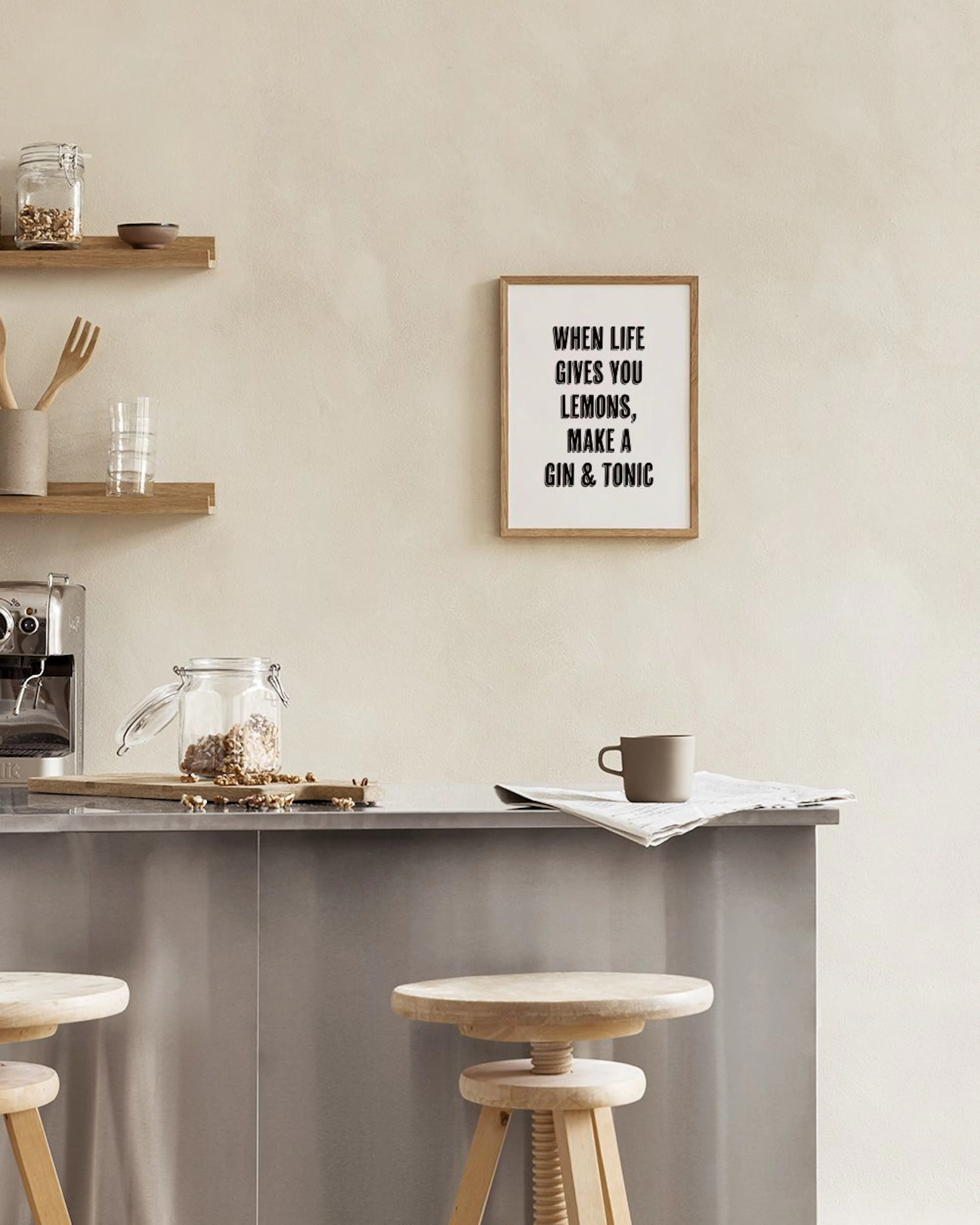 Póster en blanco y negro con la frase WHEN LIFE GIVES YOU LEMONS, MAKE A GIN & TONIC, exhibido junto a una ventana.