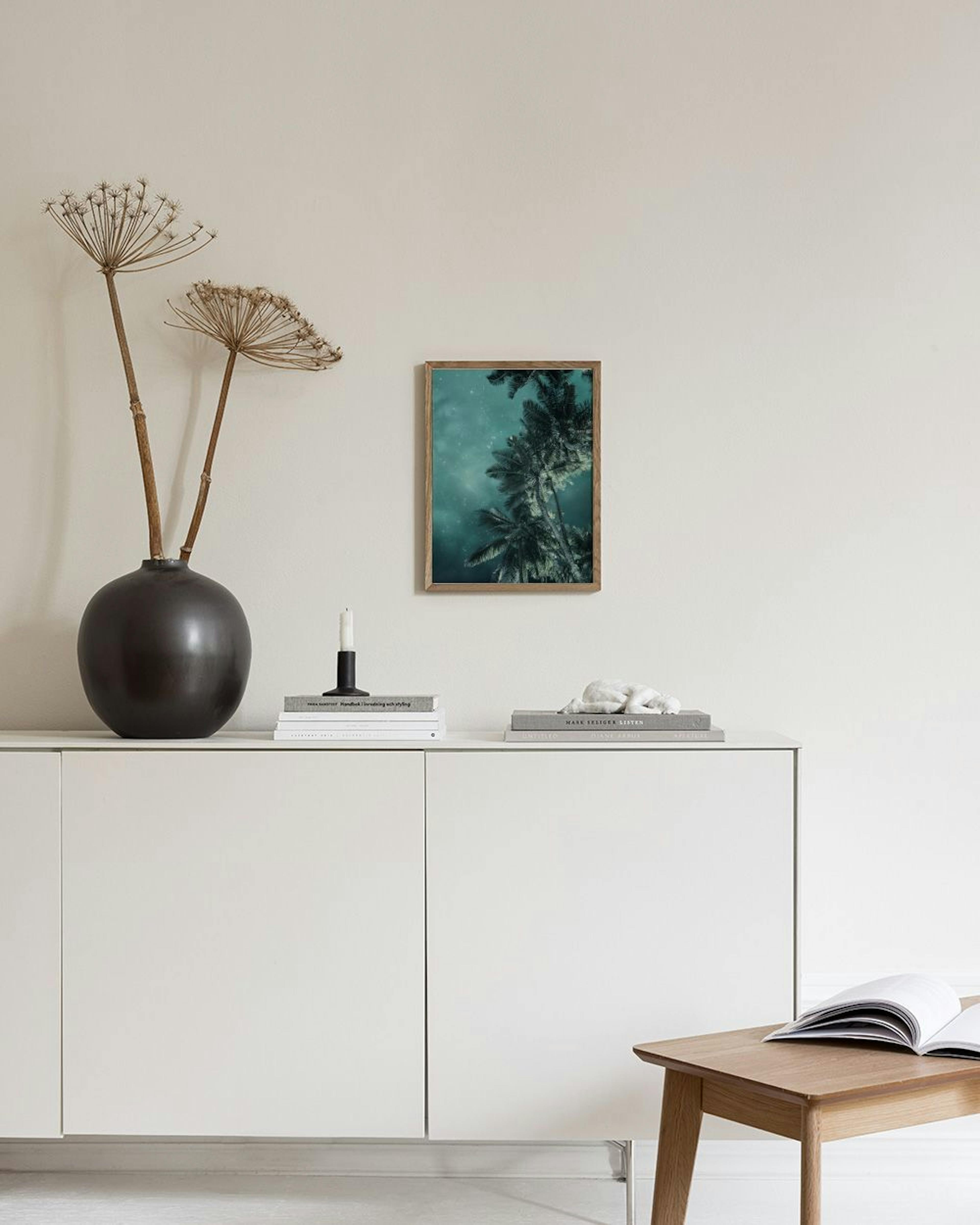 Poster con palme e cielo notturno stellato appeso in una stanza moderna con sedia e vaso.