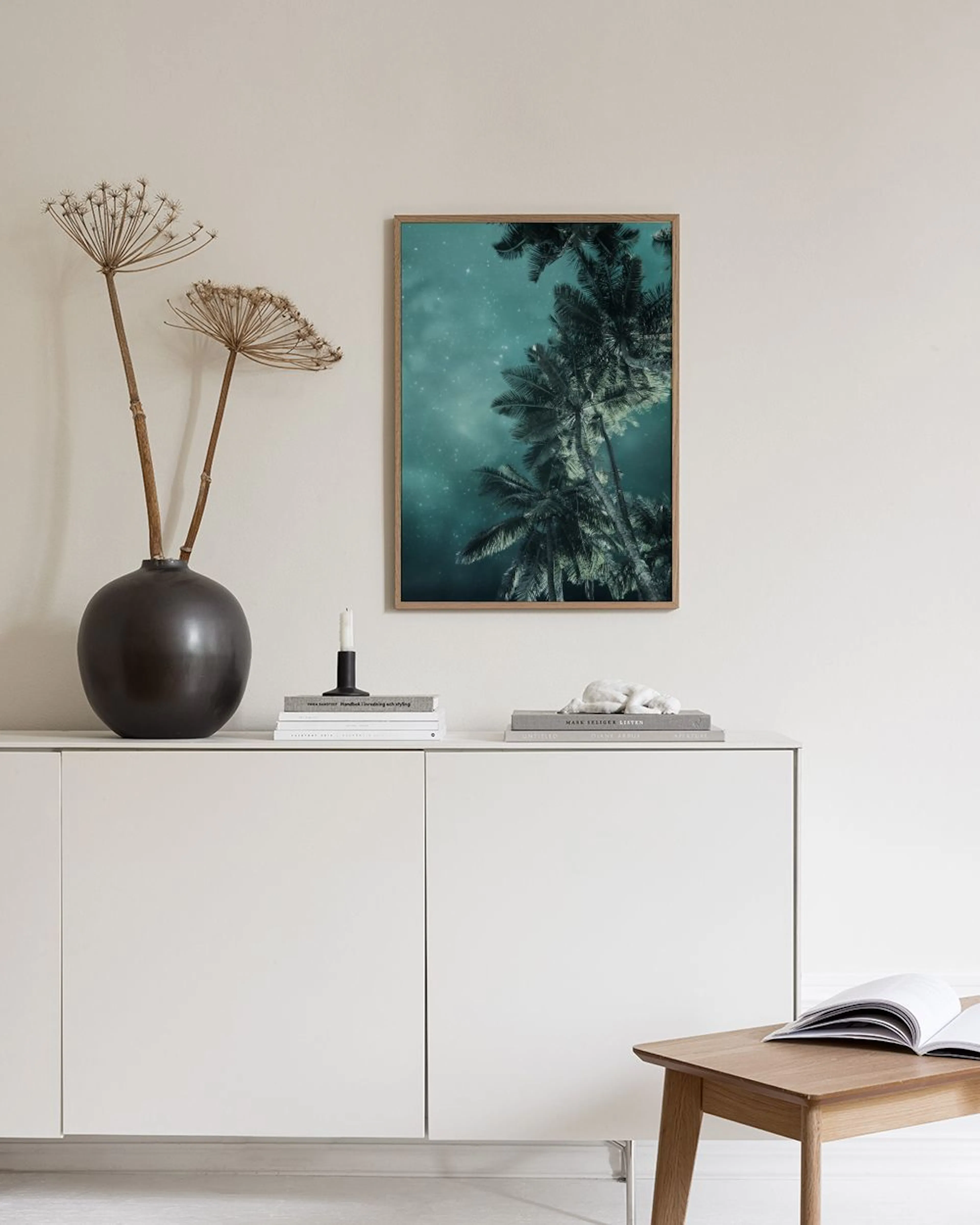 Poster con palme e cielo notturno stellato appeso in una stanza moderna con sedia e vaso.
