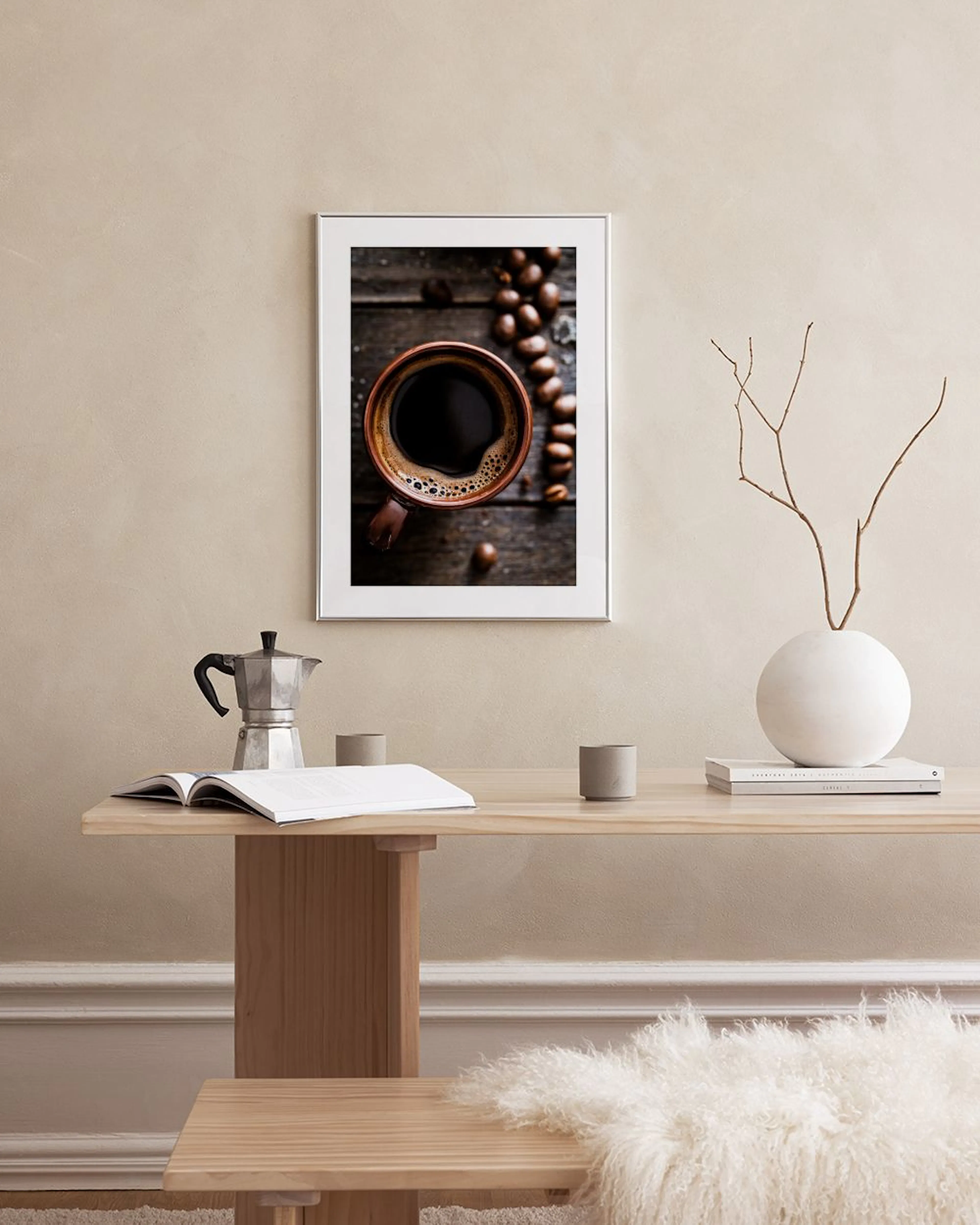 Affiche dune tasse de café et de grains sur fond de bois, accrochée dans une cuisine moderne au-dessus dune table.