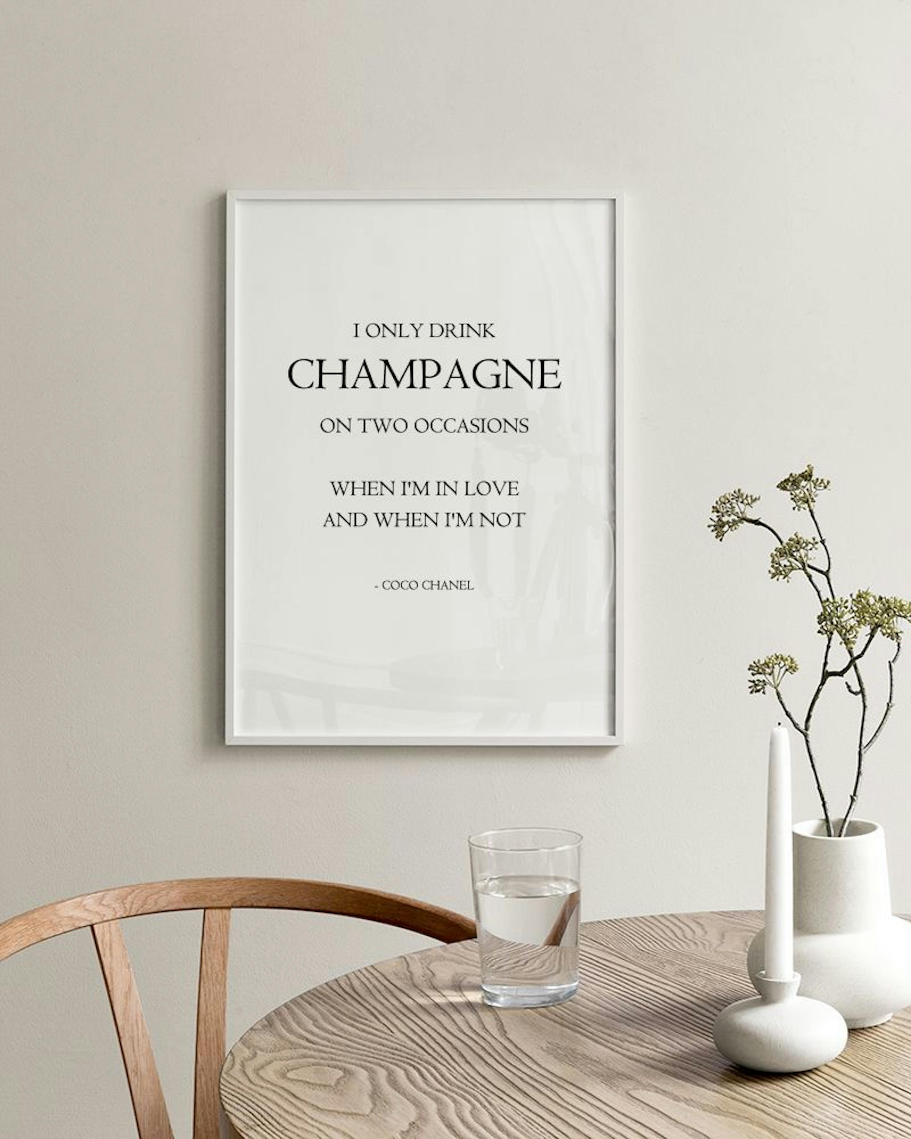 Monochrome prints with text, including Oops! Did I buy champagne again? displayed on a light wooden surface in a room.