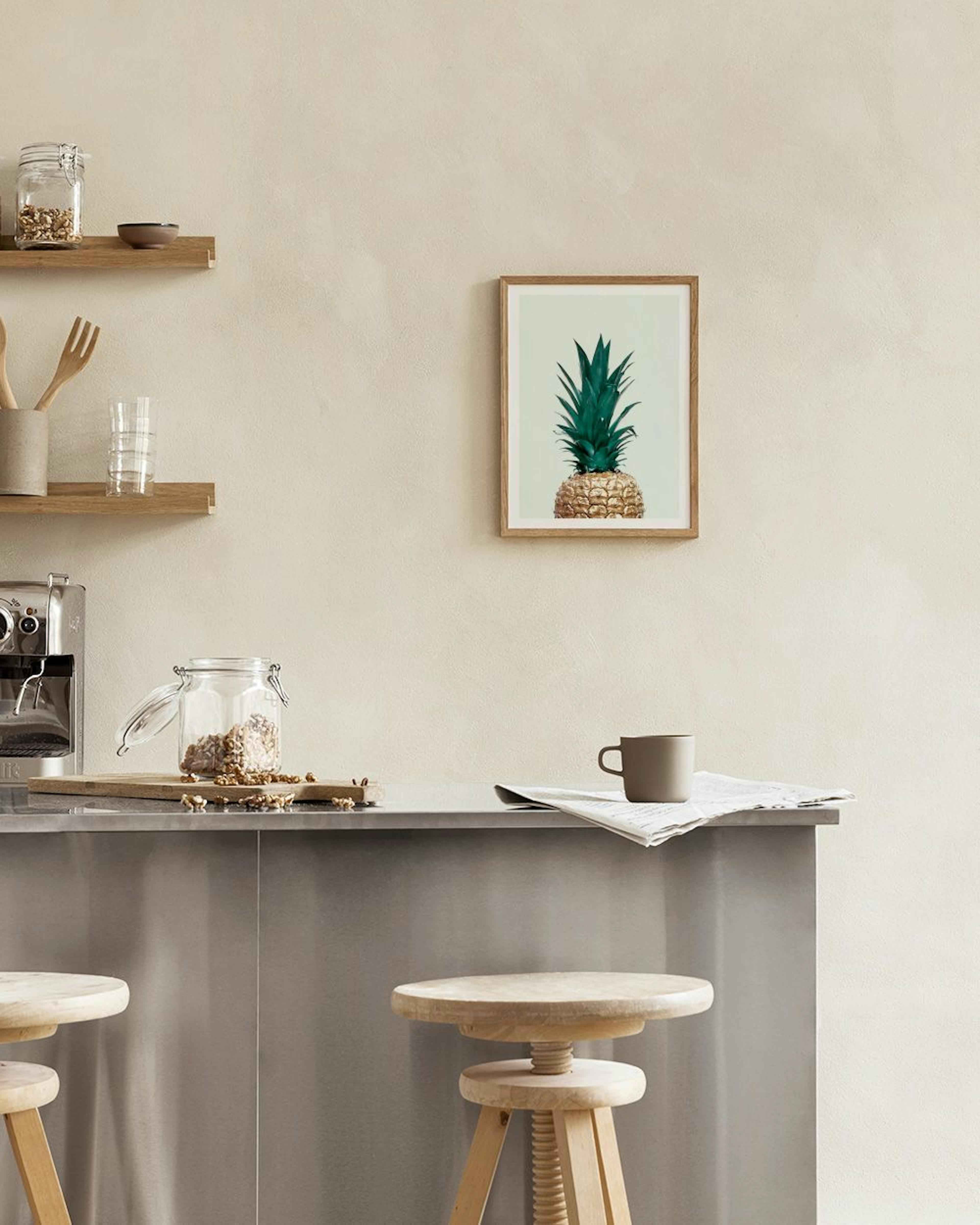 A print of a golden pineapple with green leaves, displayed on a counter with a marble background.