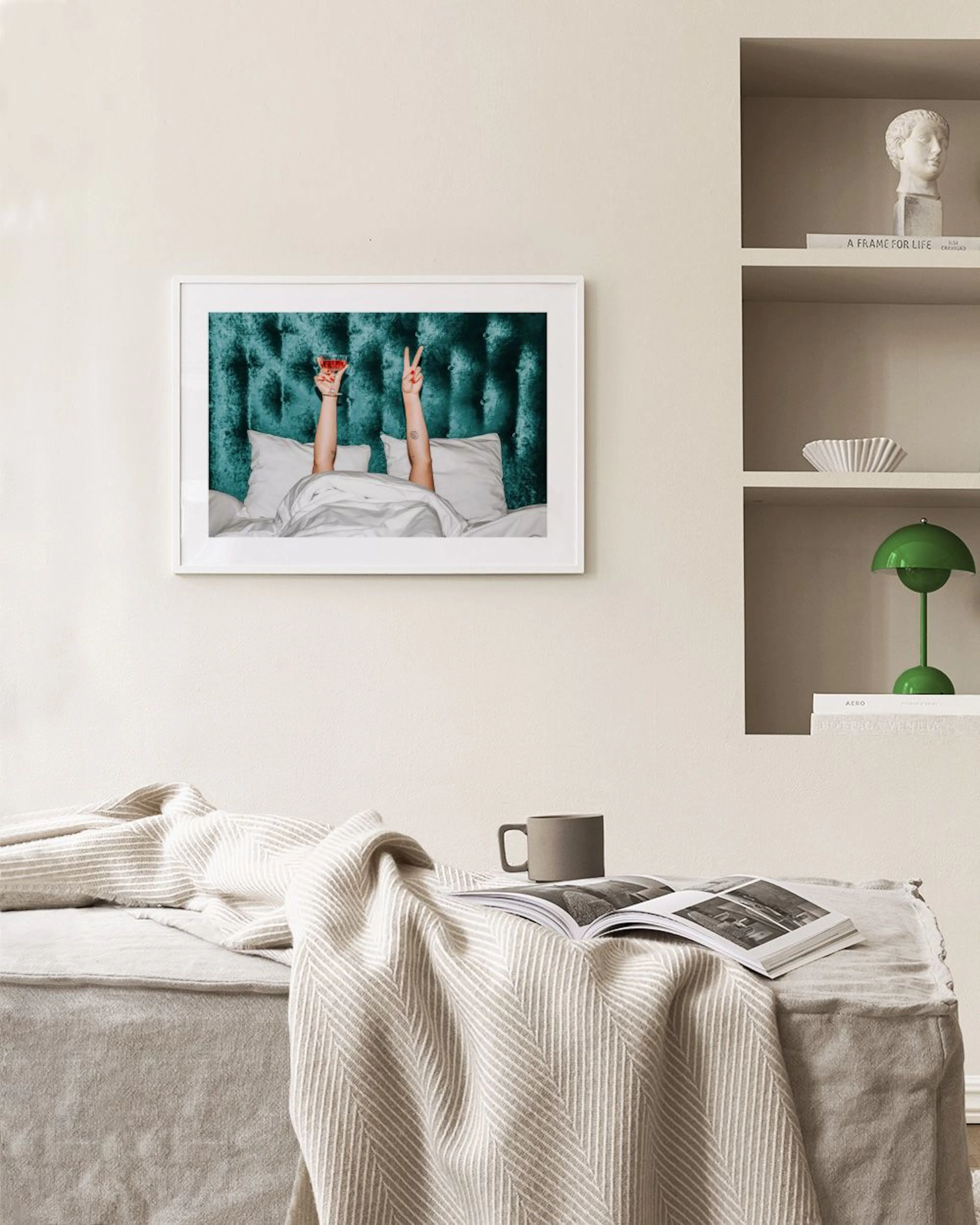 Poster van twee armen die uit bed steken, één houdt een cocktail vast en de ander maakt een V-teken, hangend boven een zwarte co