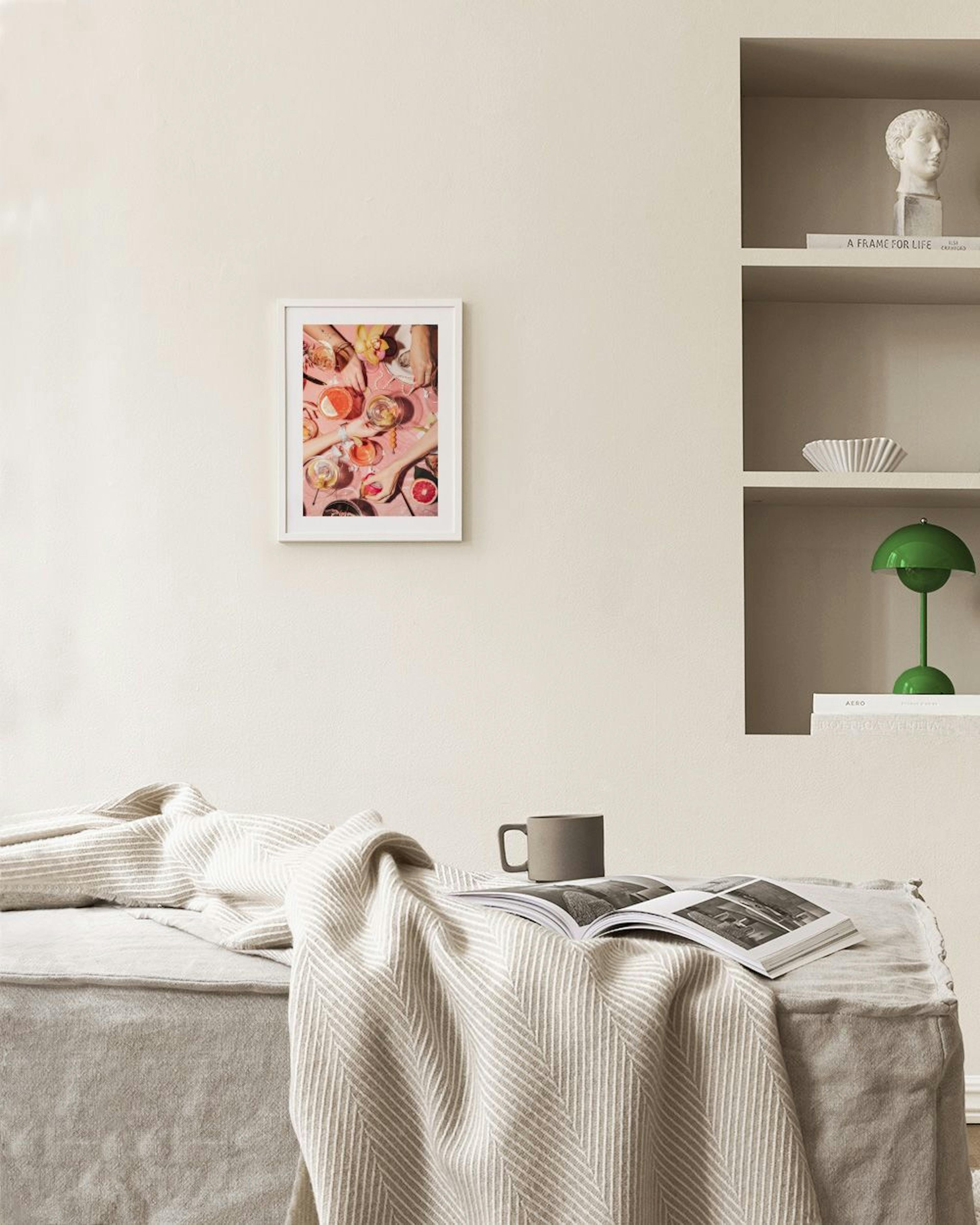 Poster met bovenaanzicht van handen die cocktails en grapefruit vasthouden, hangend boven een bijzettafel met decoratie in een k