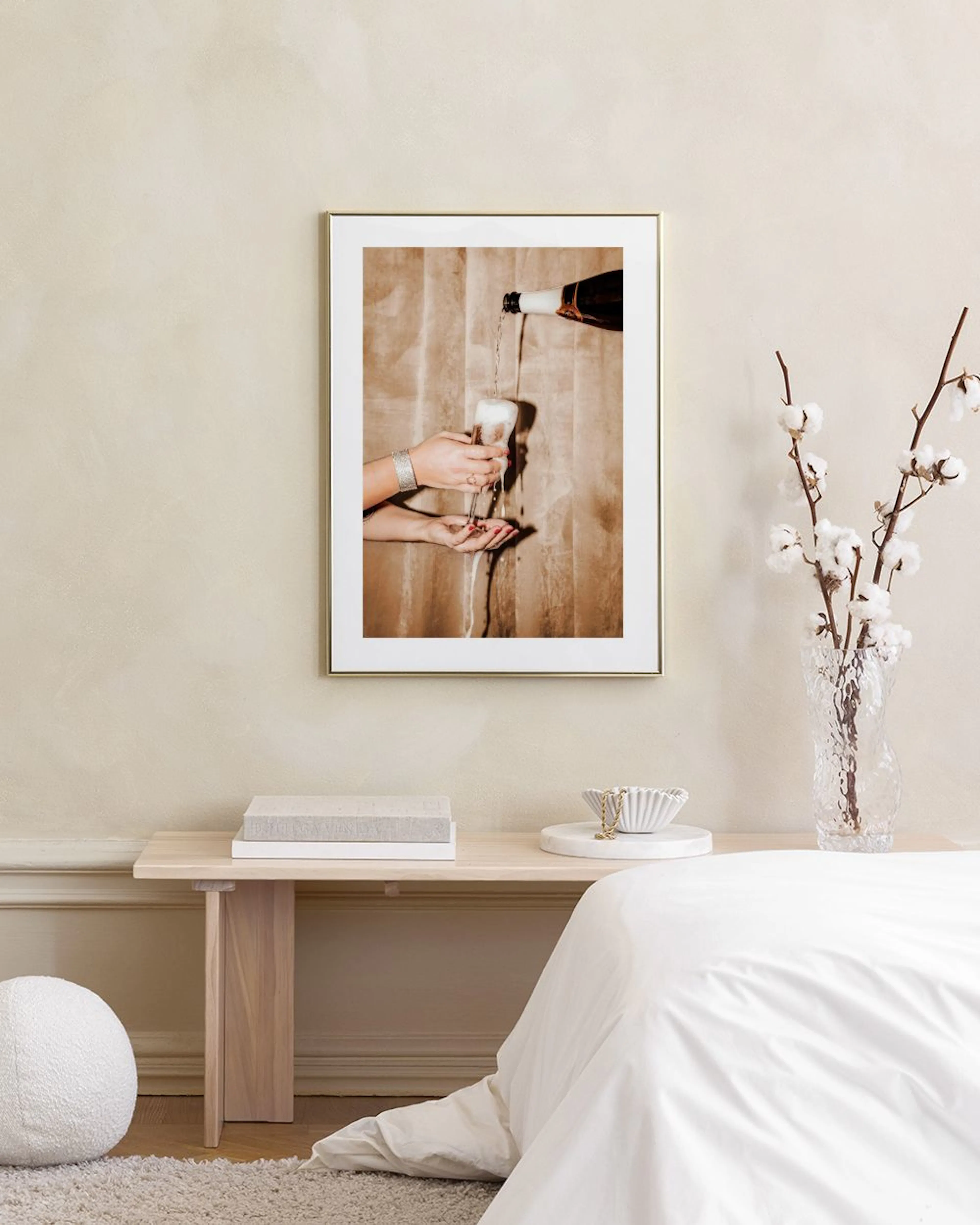 Affiche dune bouteille versant du champagne sur une main, accrochée au mur dun salon.