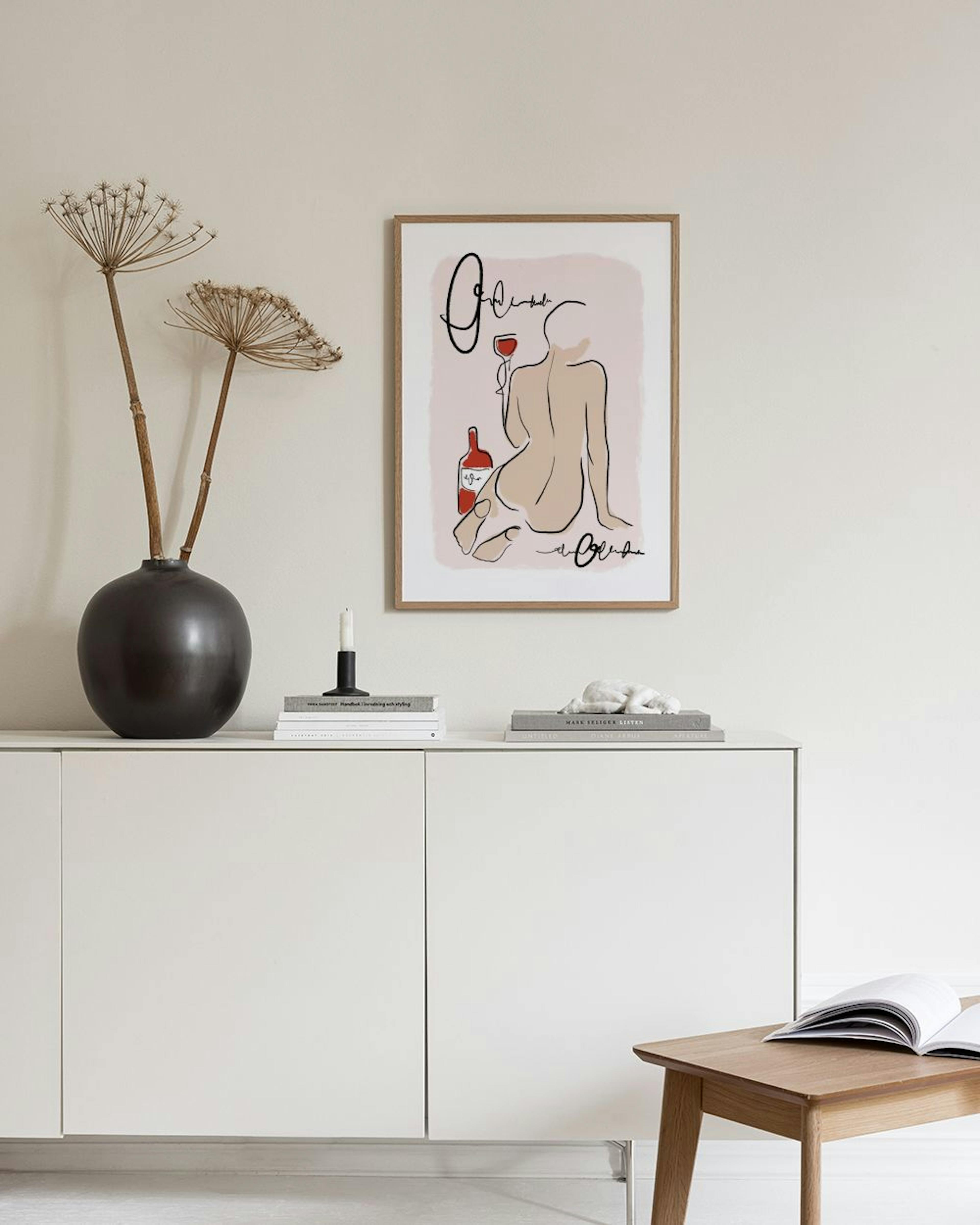 A minimalist line art print of a nude woman with a wine glass and bottle, displayed on a wall above a chair.