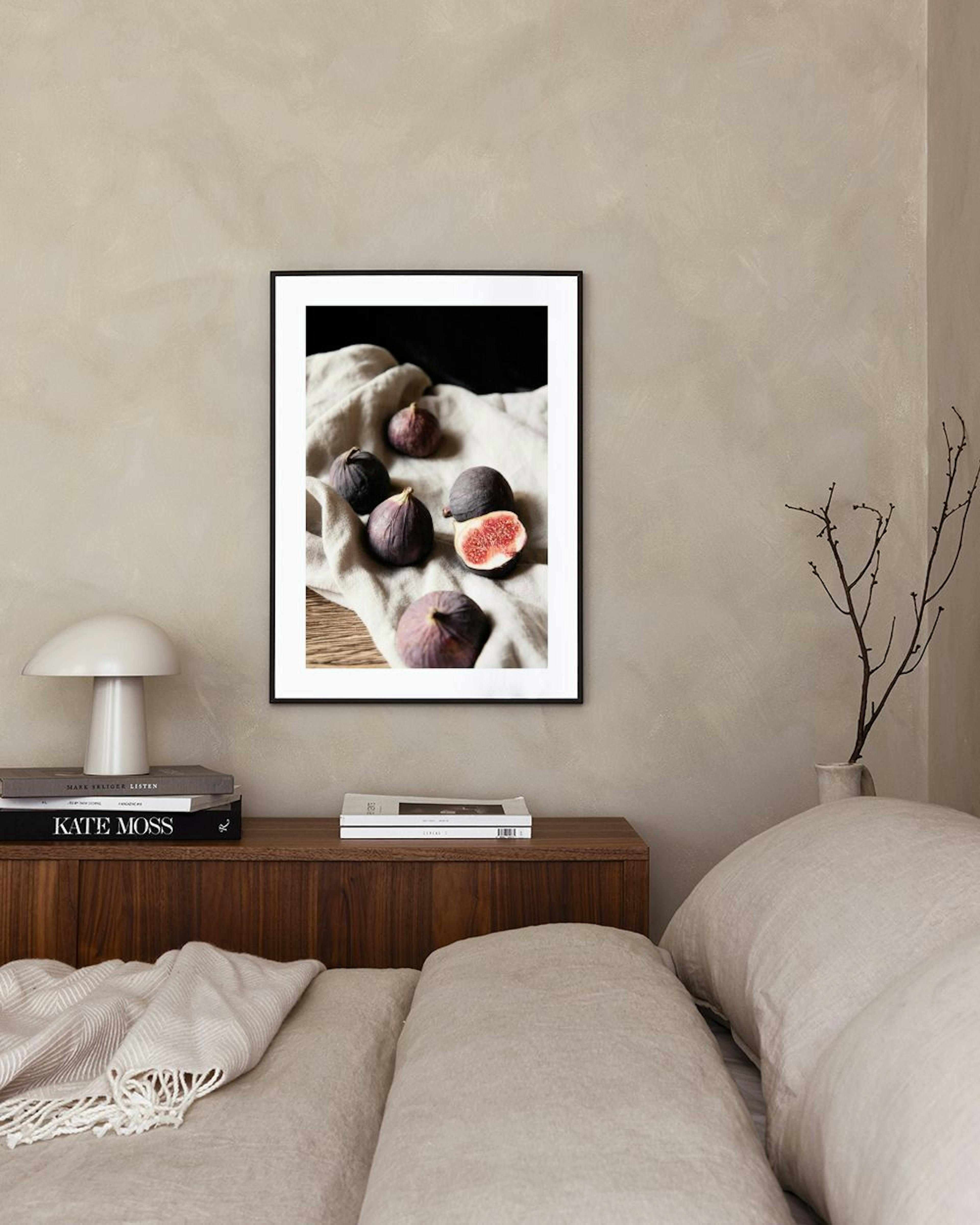 Póster de higos morados maduros sobre un paño beige, colgando en una sala de estar moderna con un sillón beige.