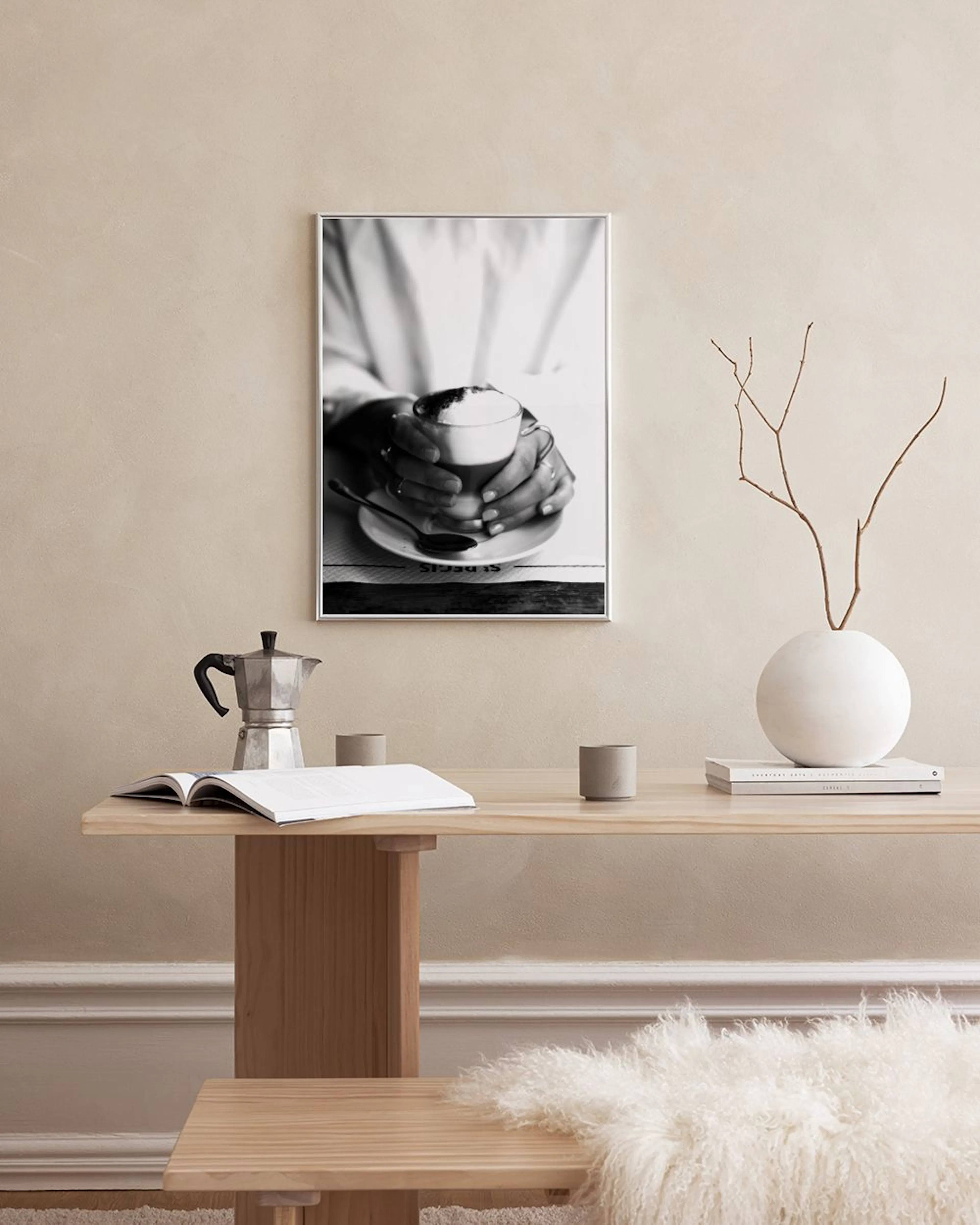 Póster en blanco y negro de manos sosteniendo una taza de café con espuma, apoyado en el alféizar de una ventana.