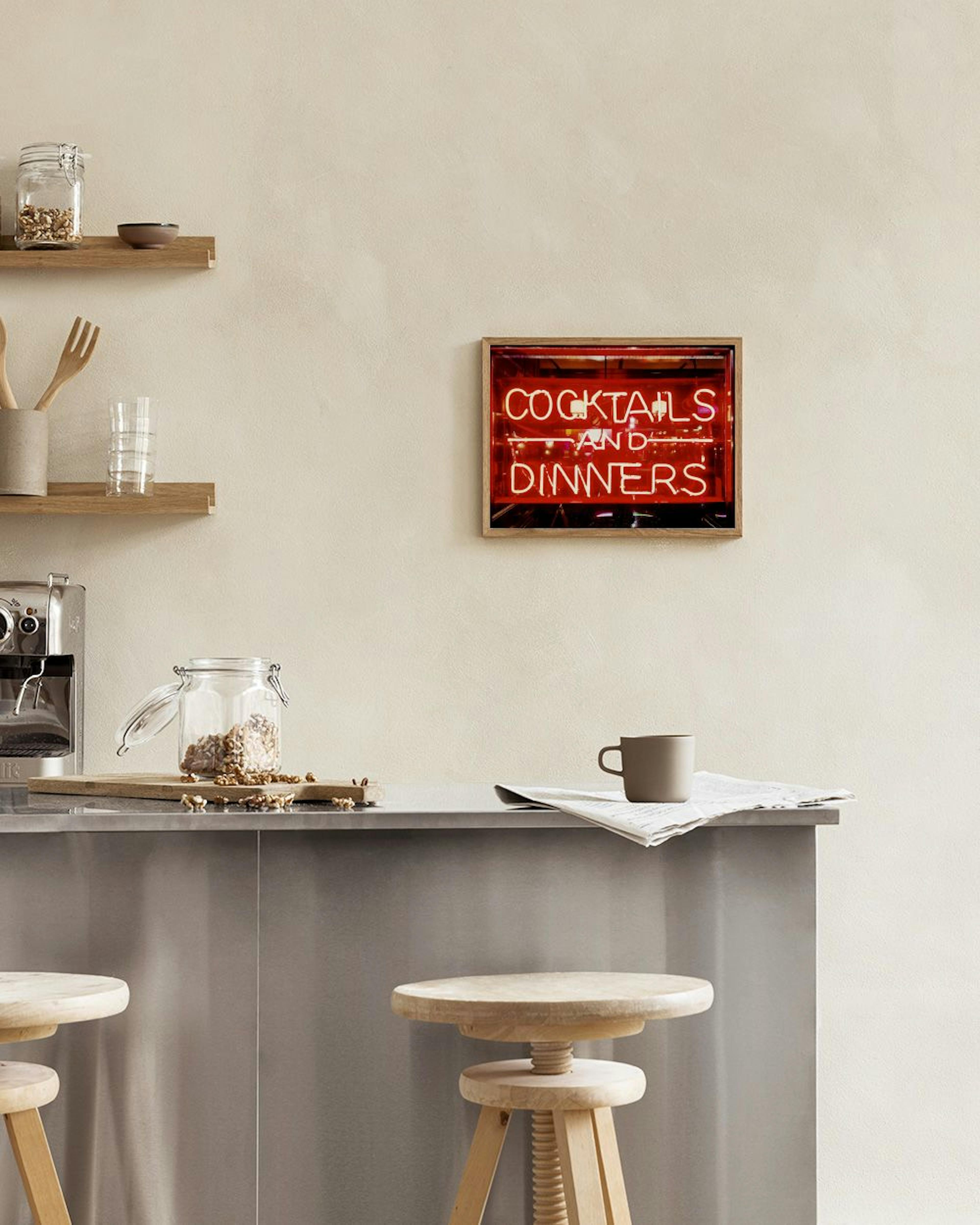 Poster van een neonreclame met de tekst COCKTAILS AND DINNERS, hangend boven een witte kubus en leren stoel.