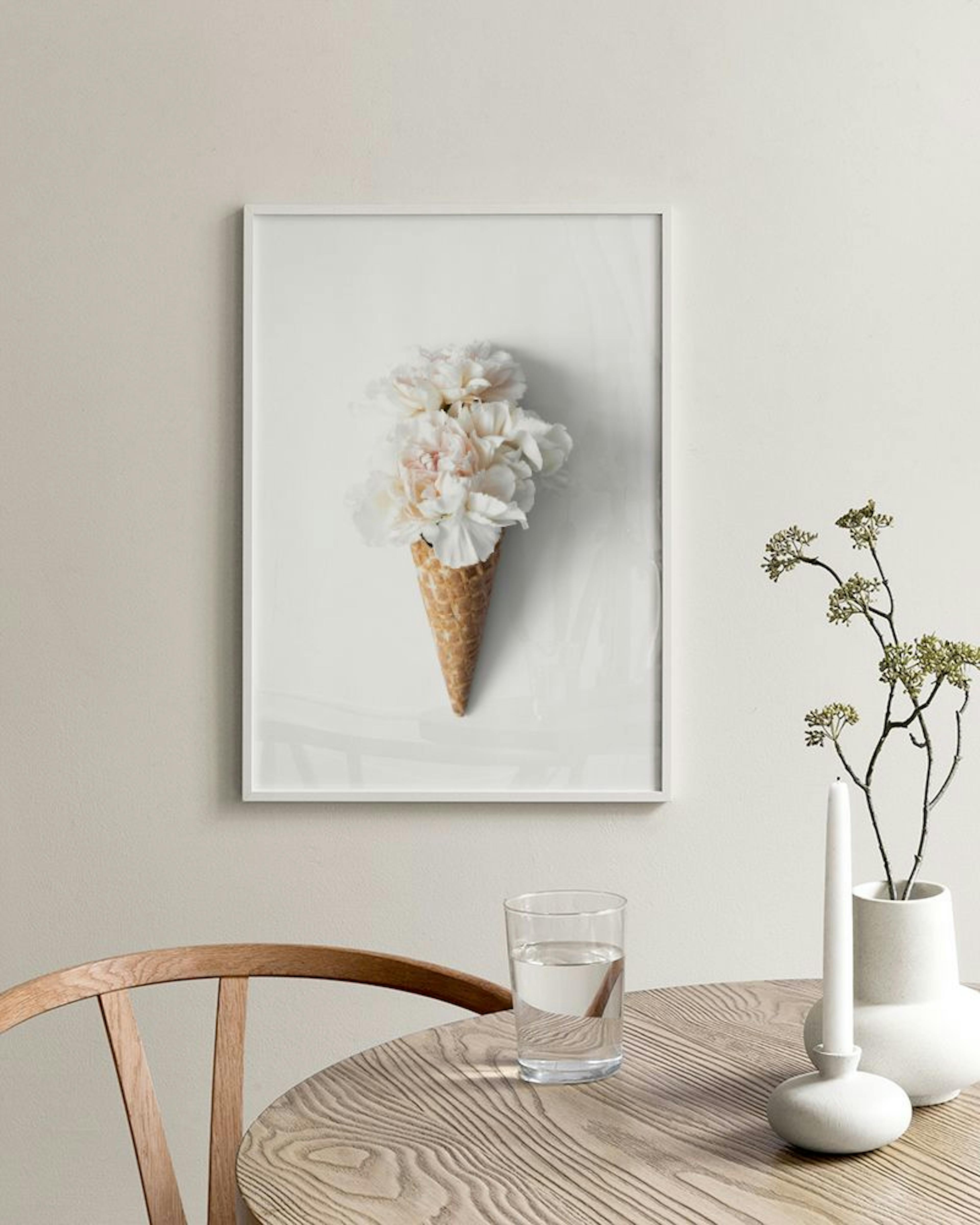 Poster mit Waffeltüte voller weißer und rosafarbener Blüten, hängt über einer weißen Kommode vor rosa Wand.