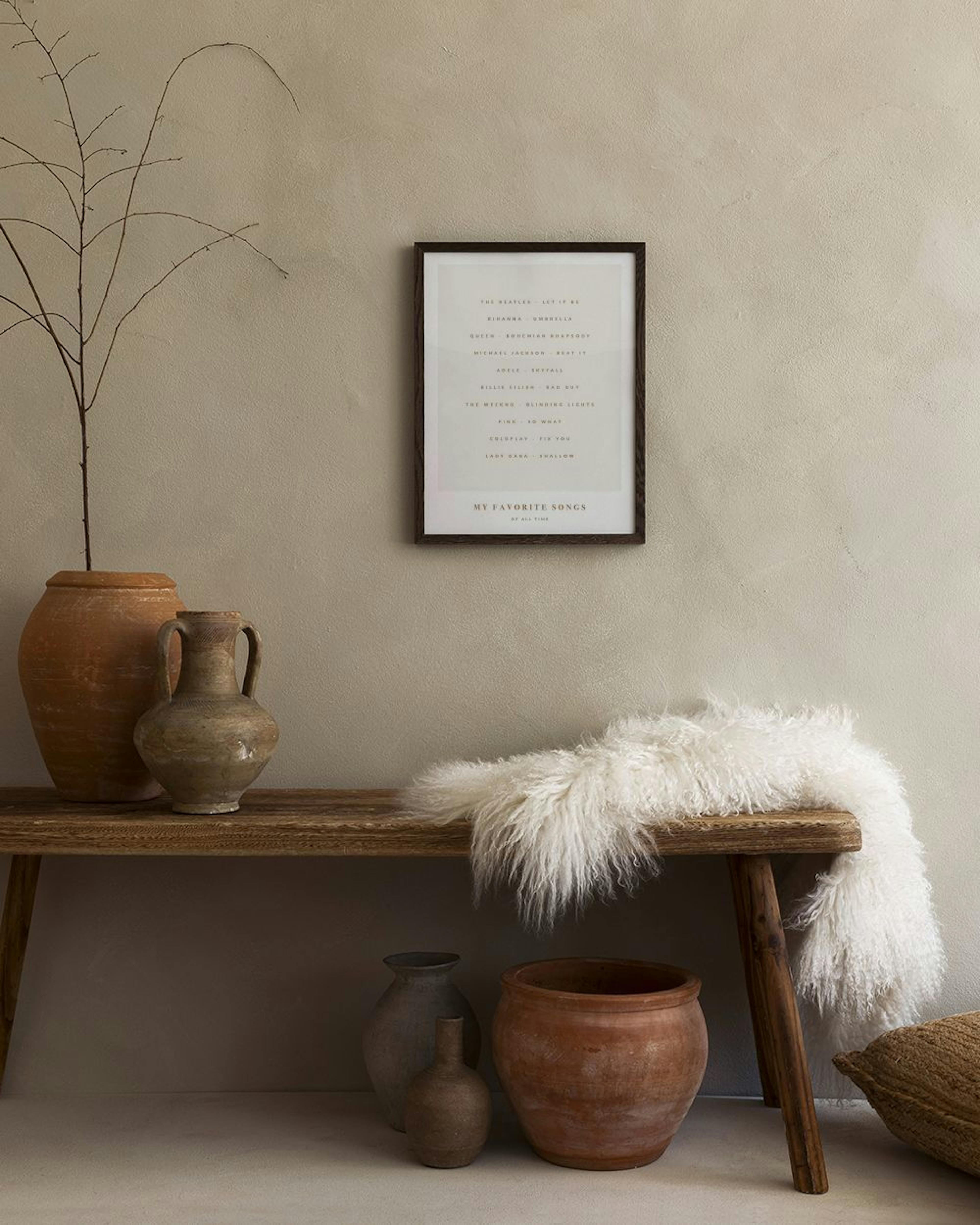 A personalized print of My Favorite Songs with artist and song titles, hanging above a wooden console table.