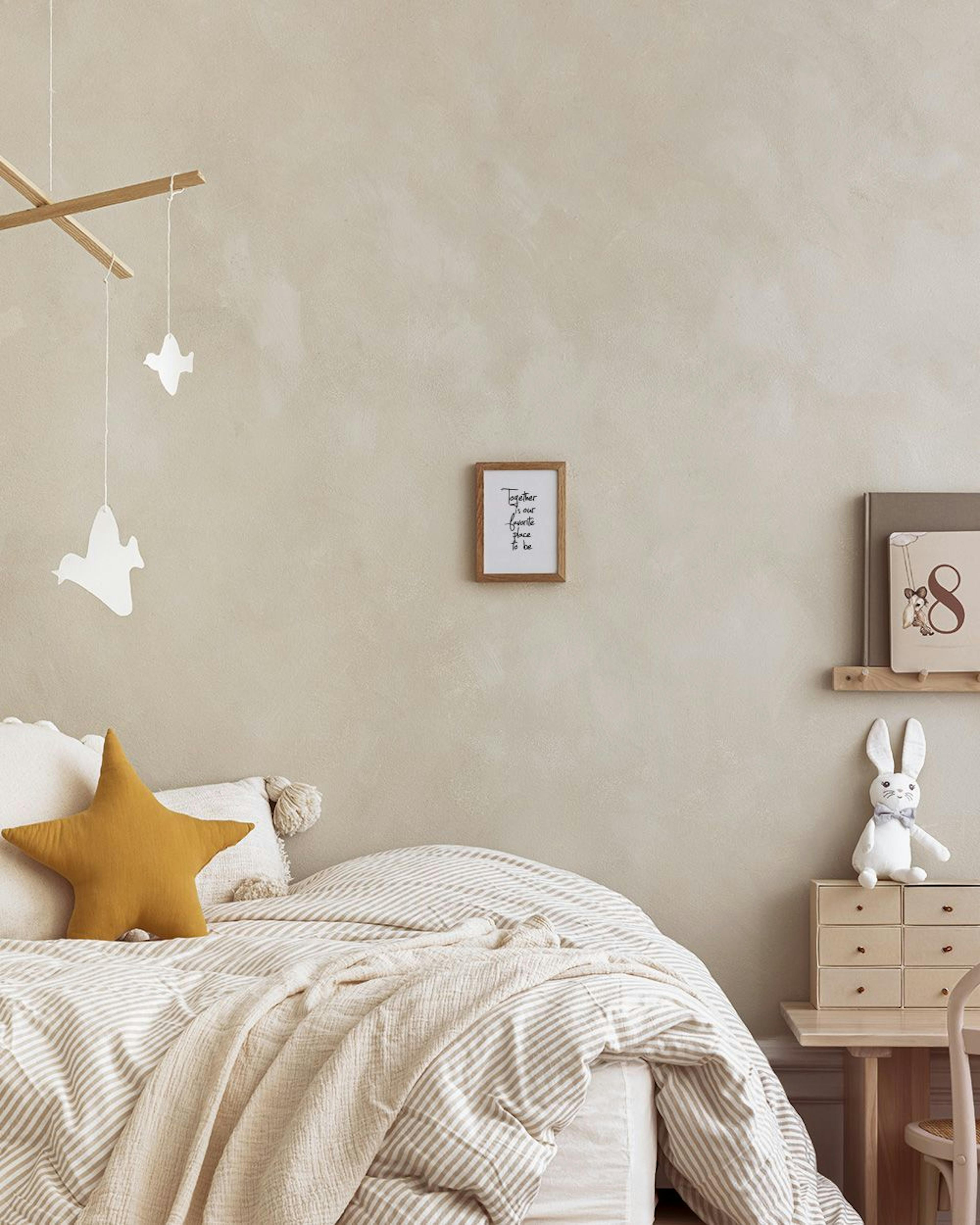 Poster mit Schriftzug Together is our favorite place to be, umgeben von Pflanzen und einer Lampe in modernem Raum.