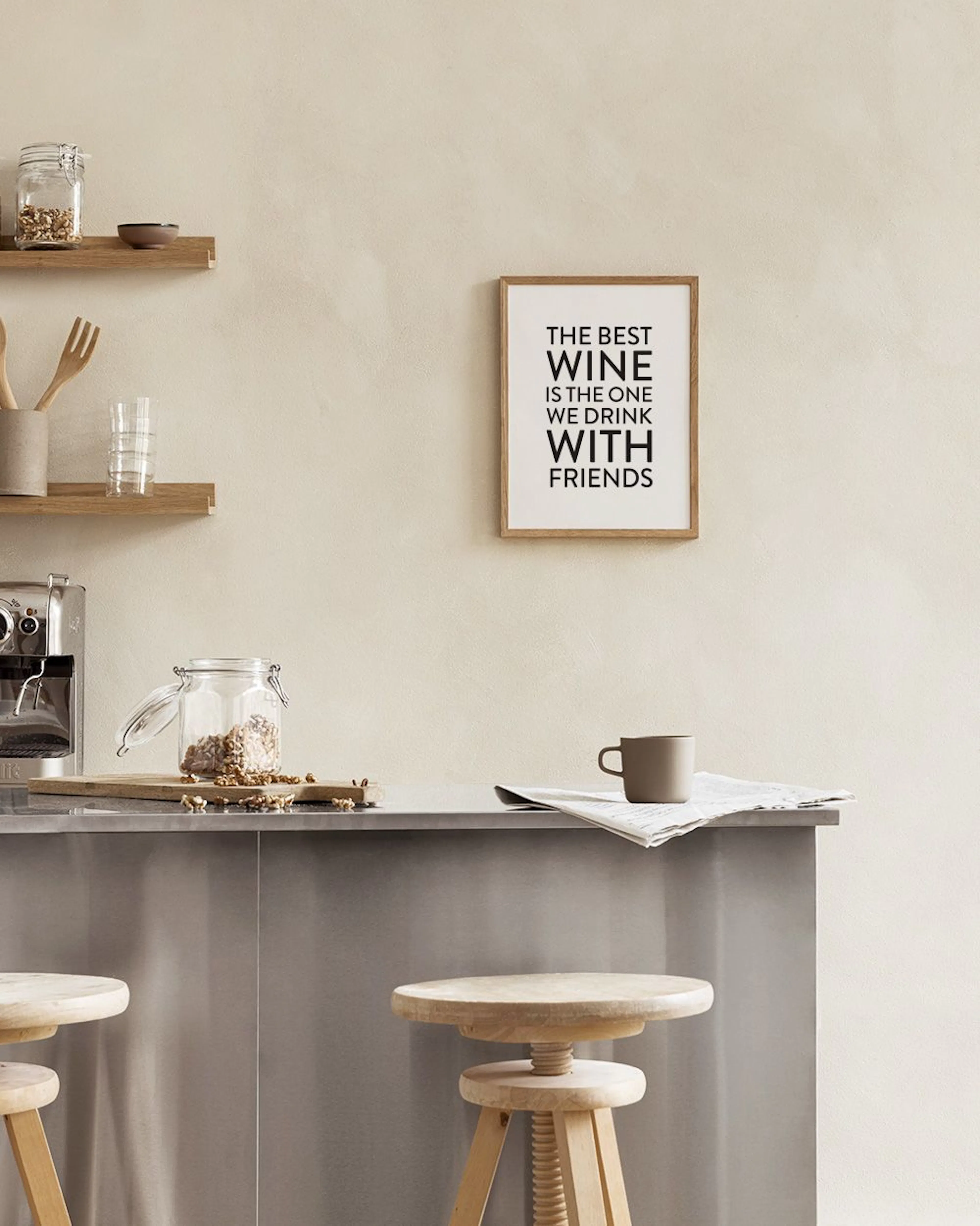 A print with the quote The best wine is the one we drink with friends in bold black text on white, displayed on a white marble s