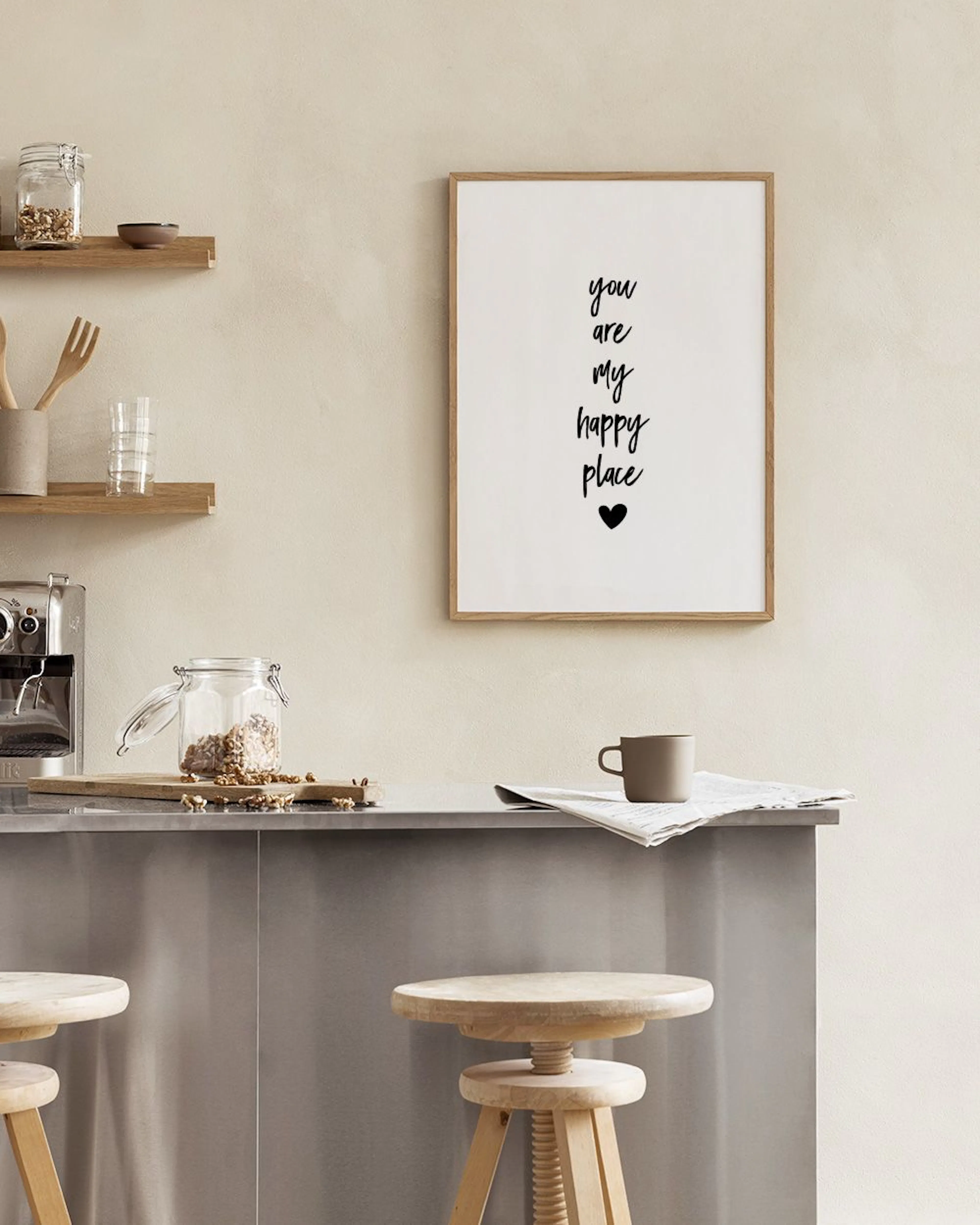 Affiche You are my happy place avec un cœur, accrochée au mur près dune chaise en rotin et dun vase.