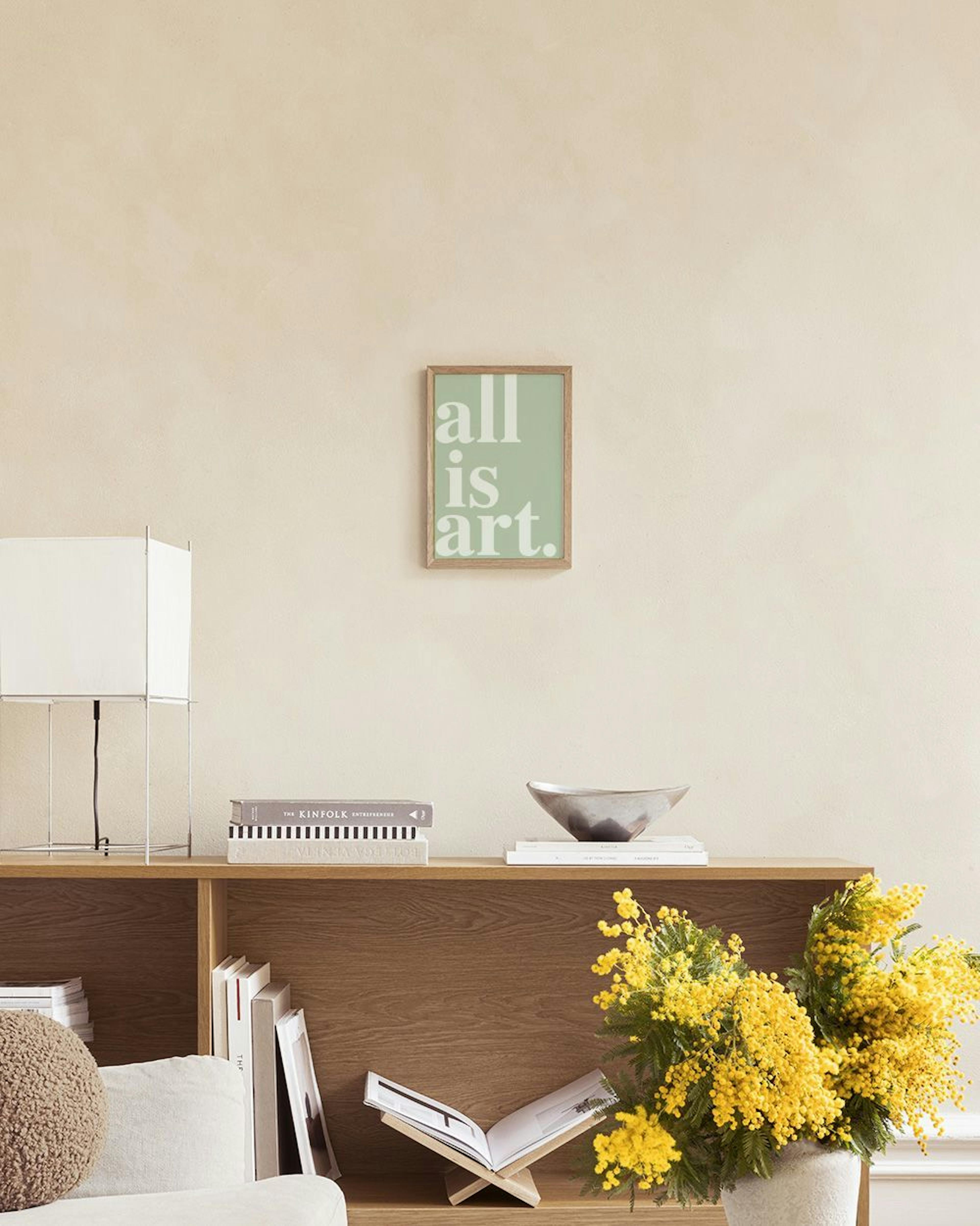 ミントグリーンの背景に「all is art.」と白い文字で書かれたポスターが、薄いグリーンのソファとライラック色の花瓶がある部屋に飾られている。