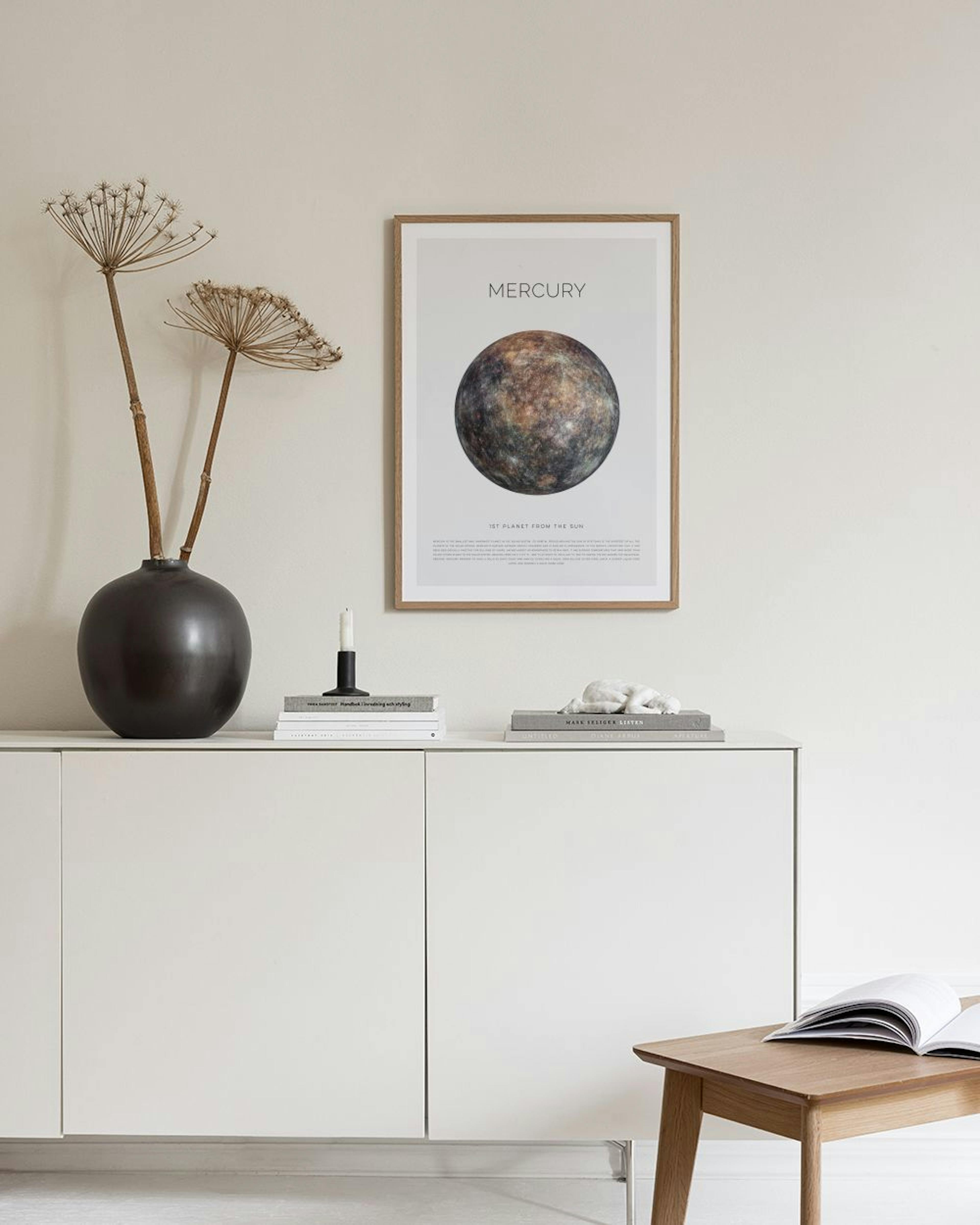Póster blanco con el planeta Mercurio en tonos marrones y grises, colgado sobre un escritorio de madera con libros.