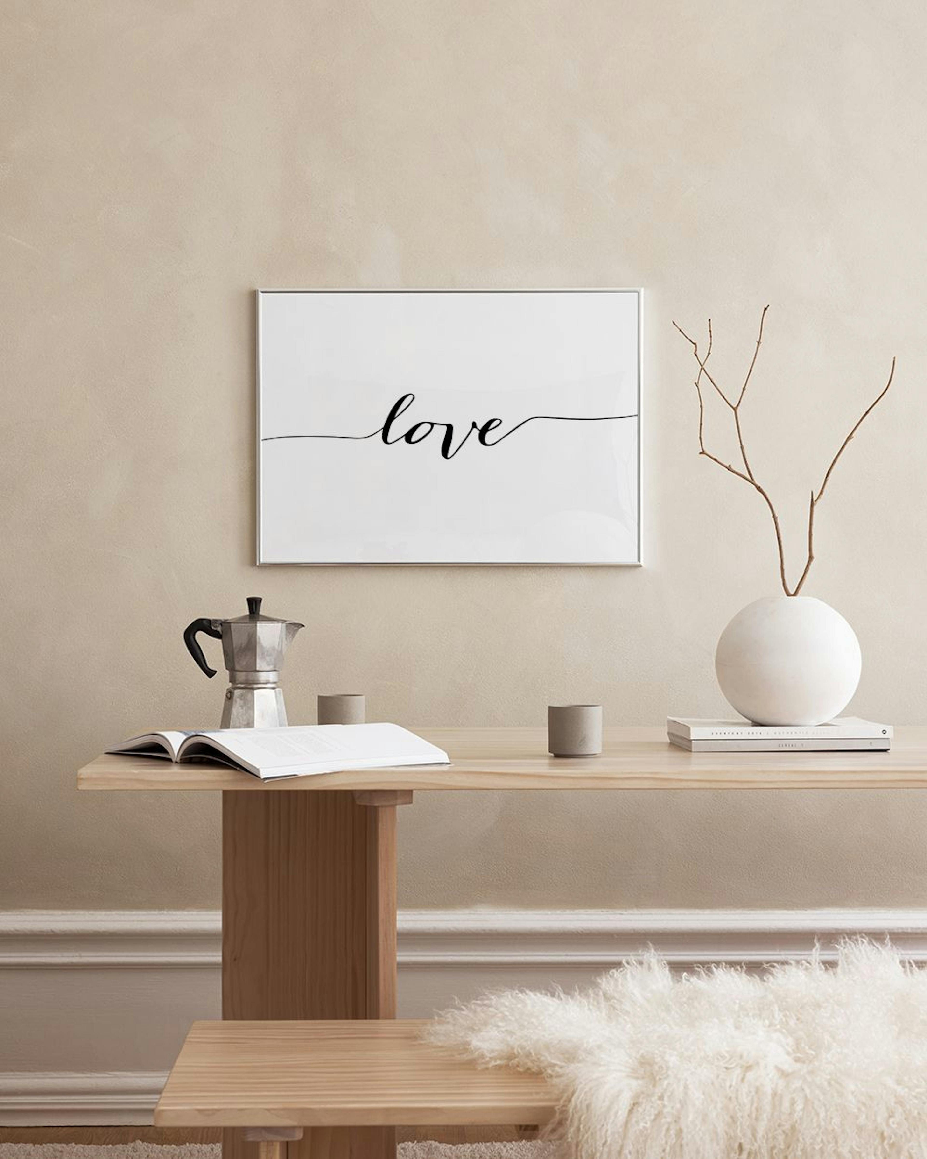 白い壁に「love」と書かれた文字のポスターが飾られ、隣にはサイドテーブルやソファがある部屋の様子。