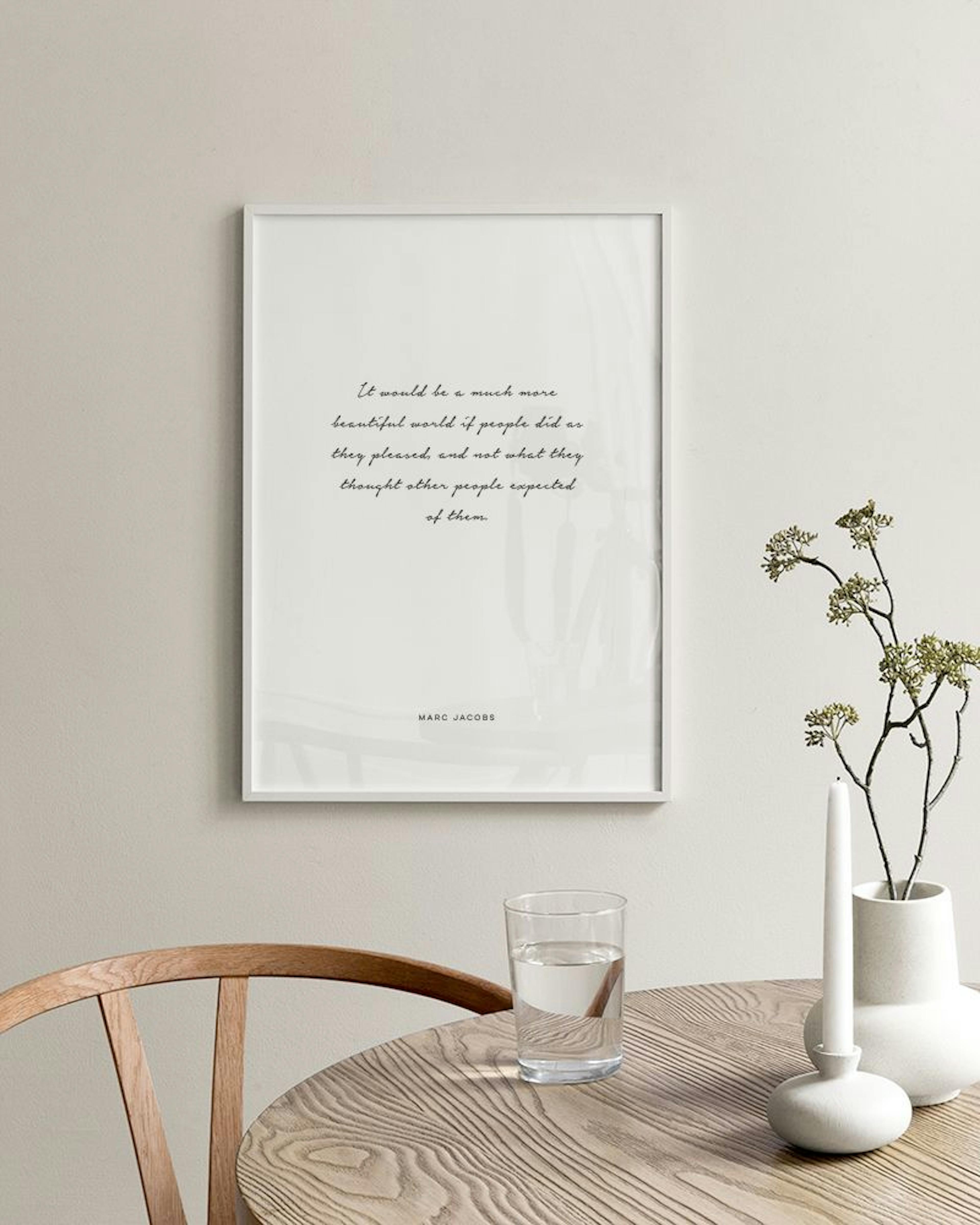 Poster med citat av Marc Jacobs i svart text på vit bakgrund, hängande på en grå vägg med två glasflaskor bredvid.