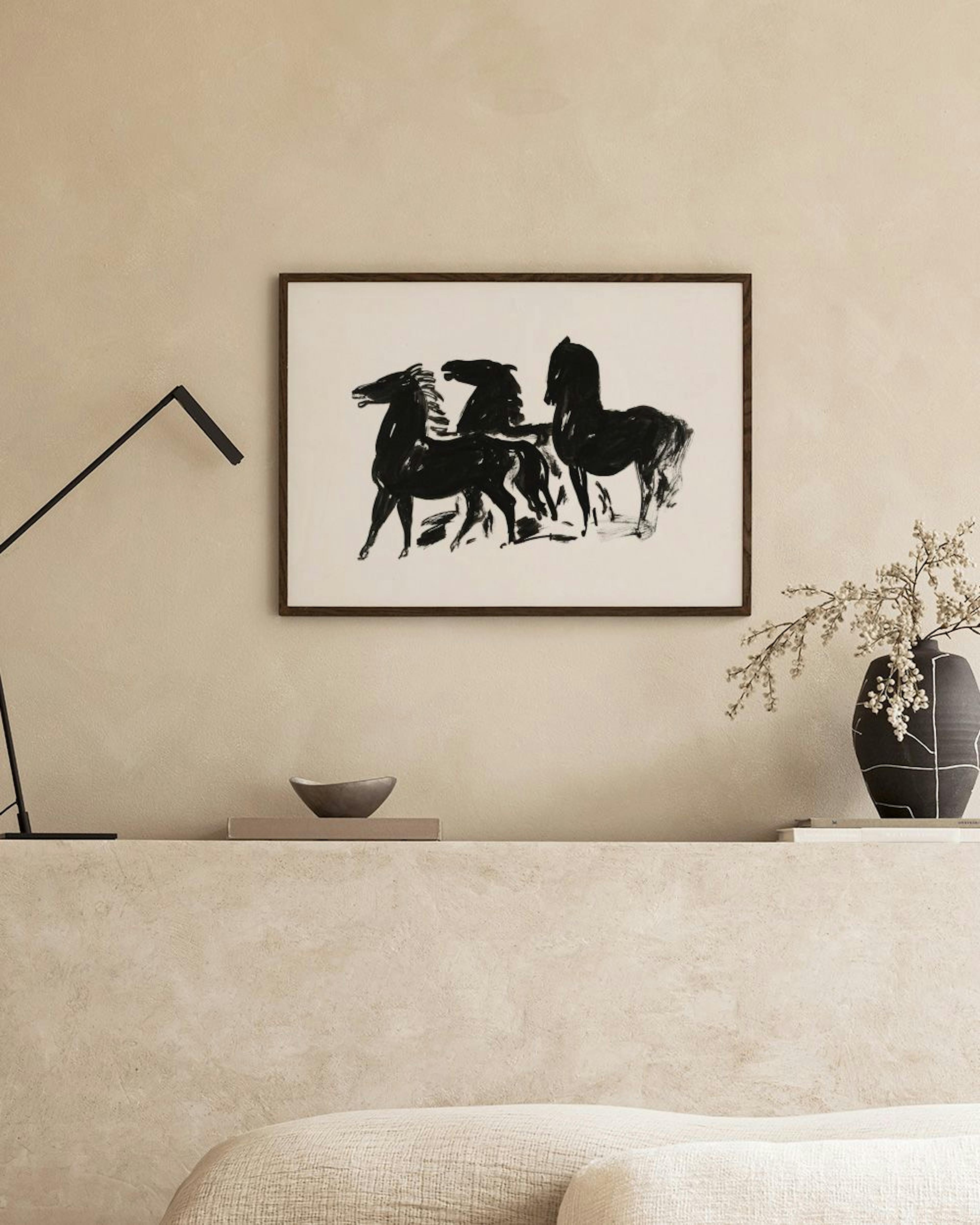 Poster met drie zwarte paarden in abstracte stijl, hangend boven een bed met wit beddengoed en een open boek.