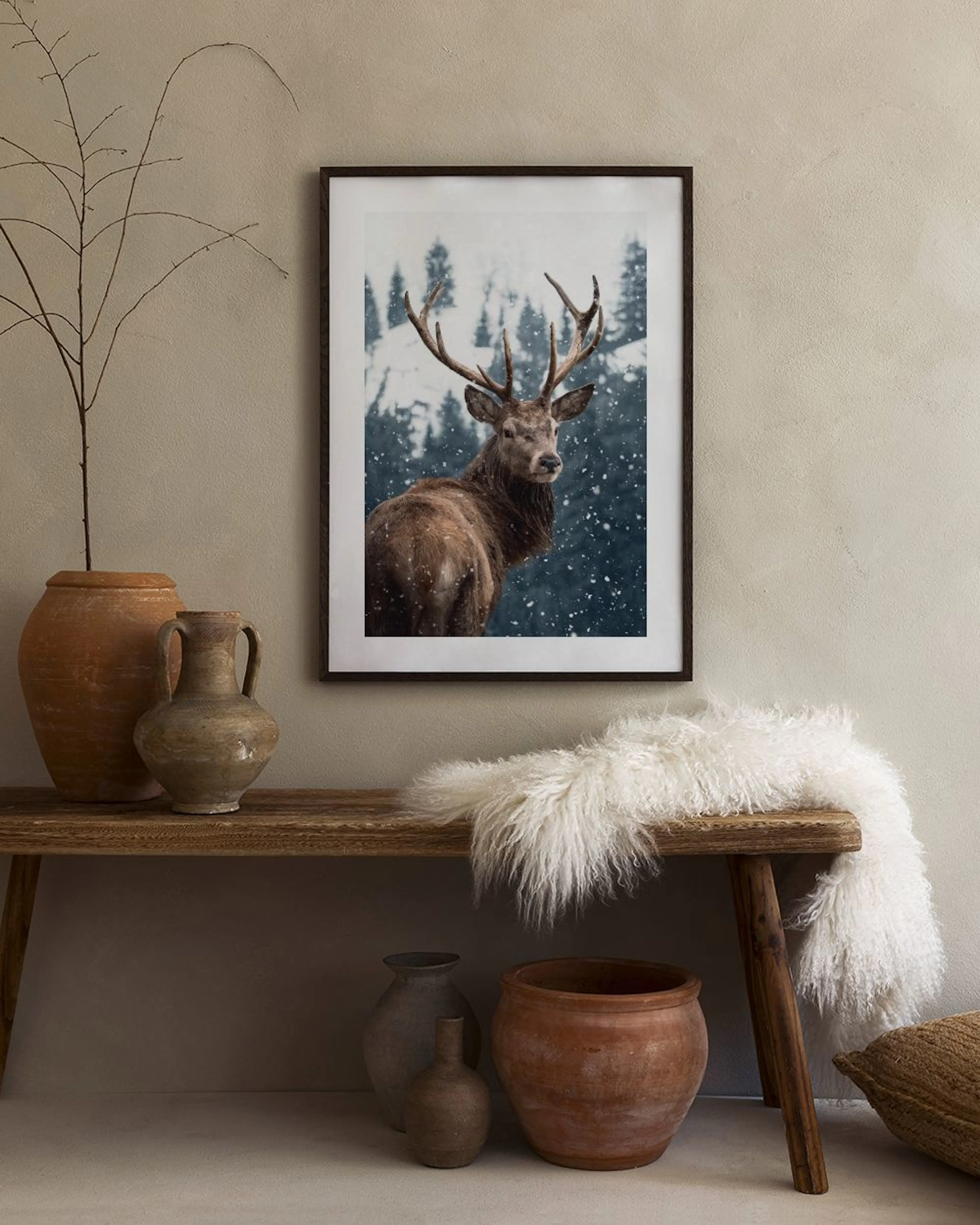 Póster de un majestuoso ciervo con grandes cuernos en un bosque nevado, con abetos borrosos de fondo.