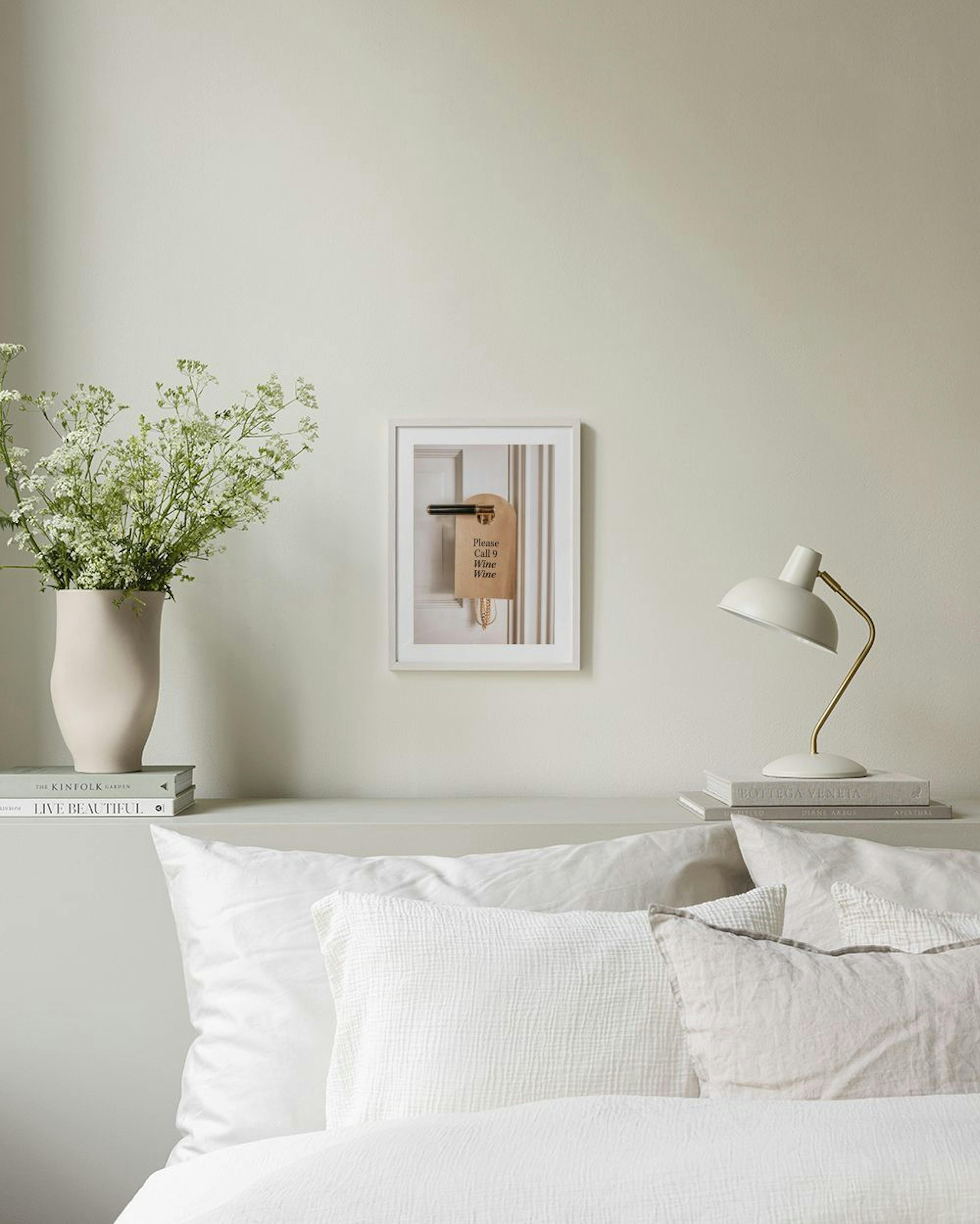 A print of a hotel door hanger that reads Please Call 9 Wine Wine Wine hanging in a cozy bedroom.