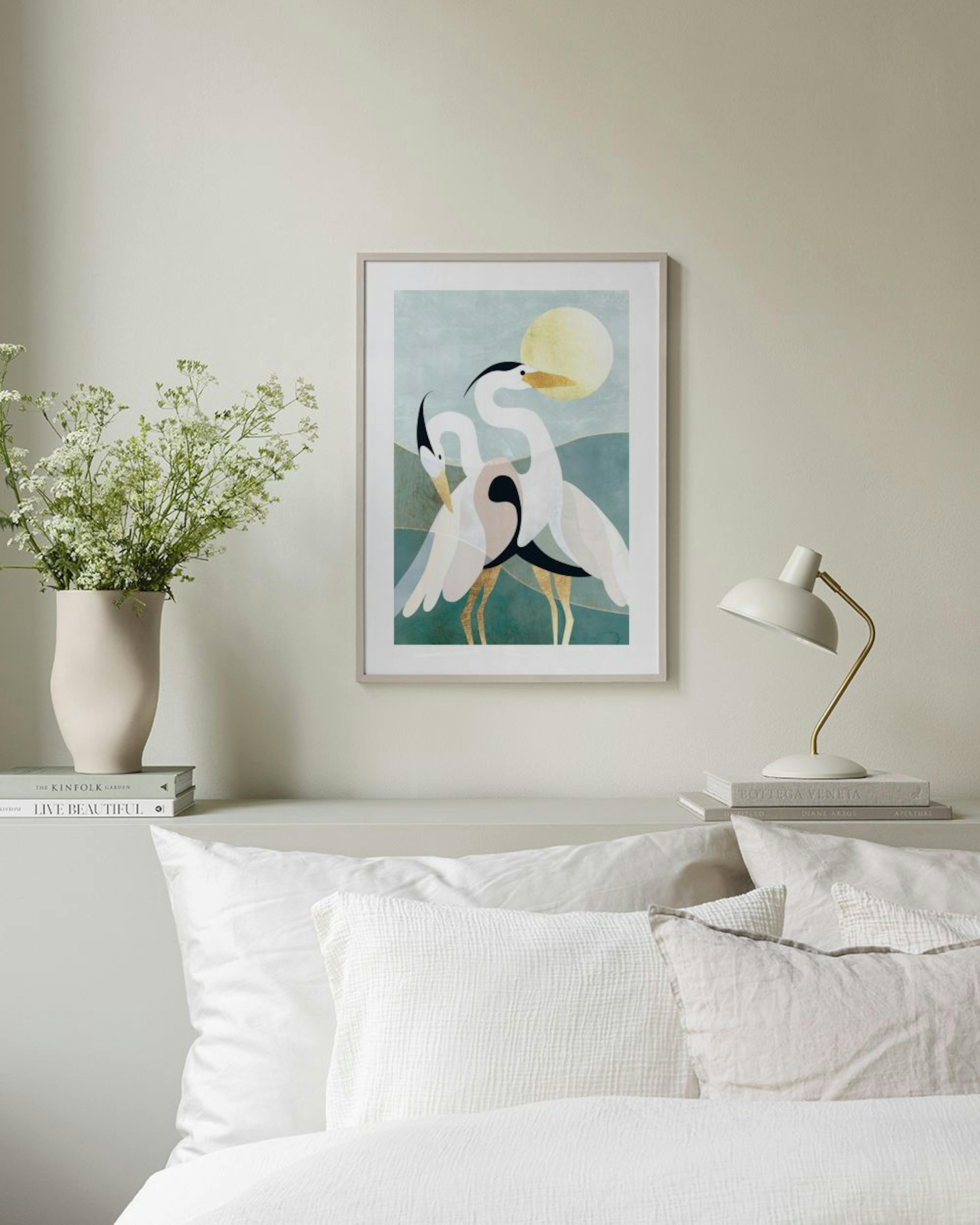 Affiche avec deux hérons stylisés et le soleil, sur un fond de montagnes vertes, affichée dans un salon.