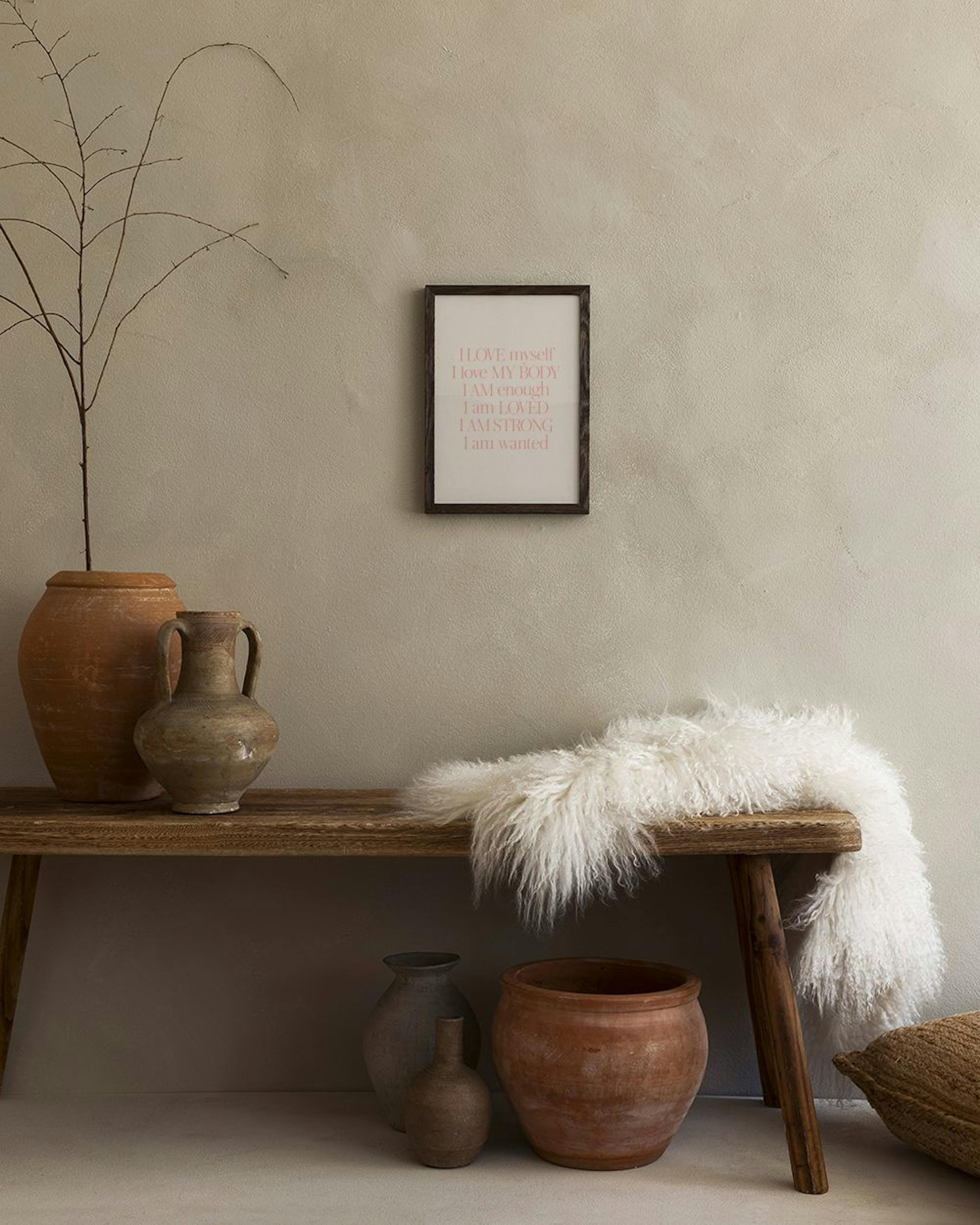 Plakat med lyserøde, motiverende ord som I LOVE myself, I love MY BODY på hvid baggrund, hængende over en mintgrøn sofa med lill