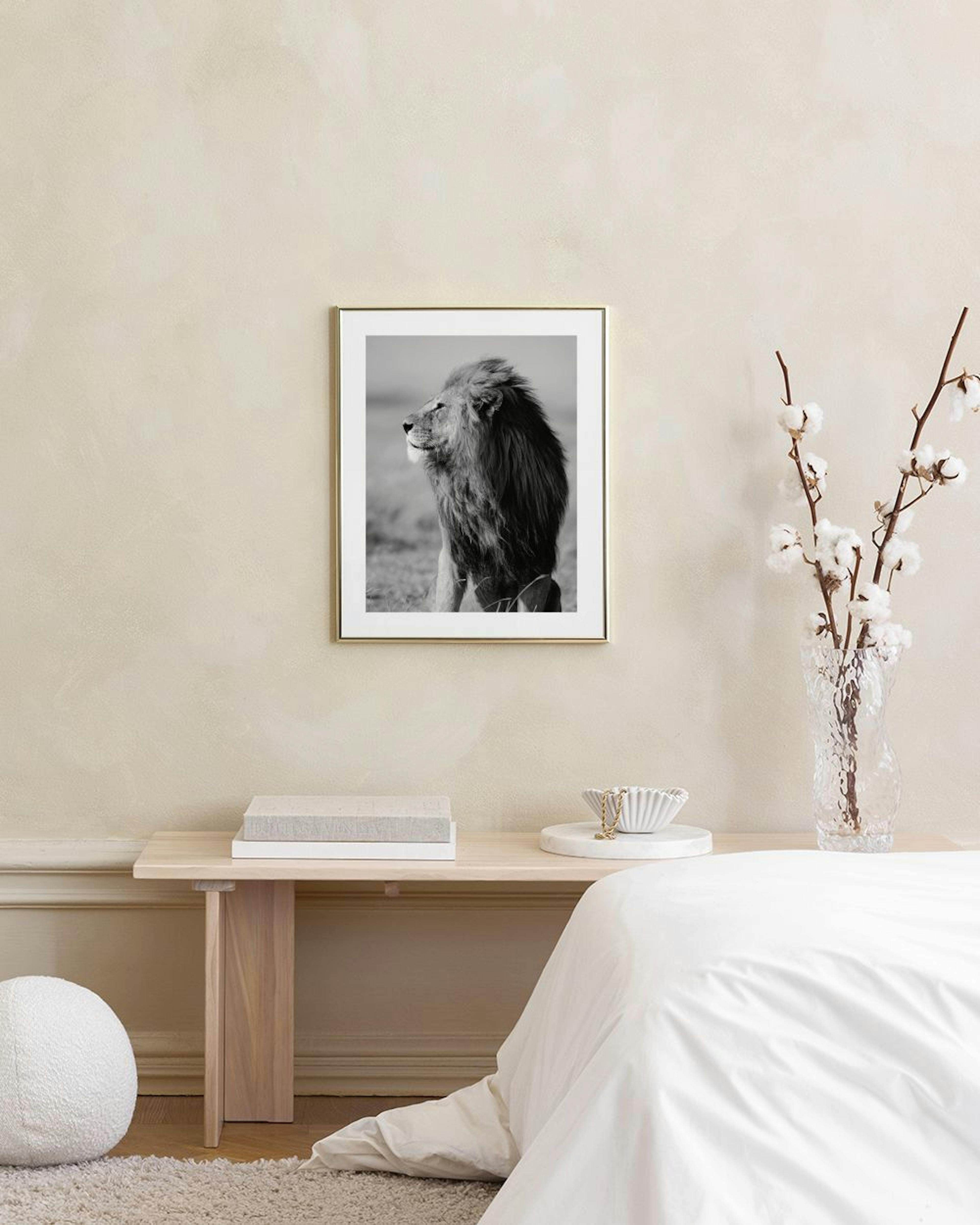 Póster de un majestuoso león de perfil en blanco y negro, colgando sobre un banco de concreto con un libro y un jarrón de vidrio