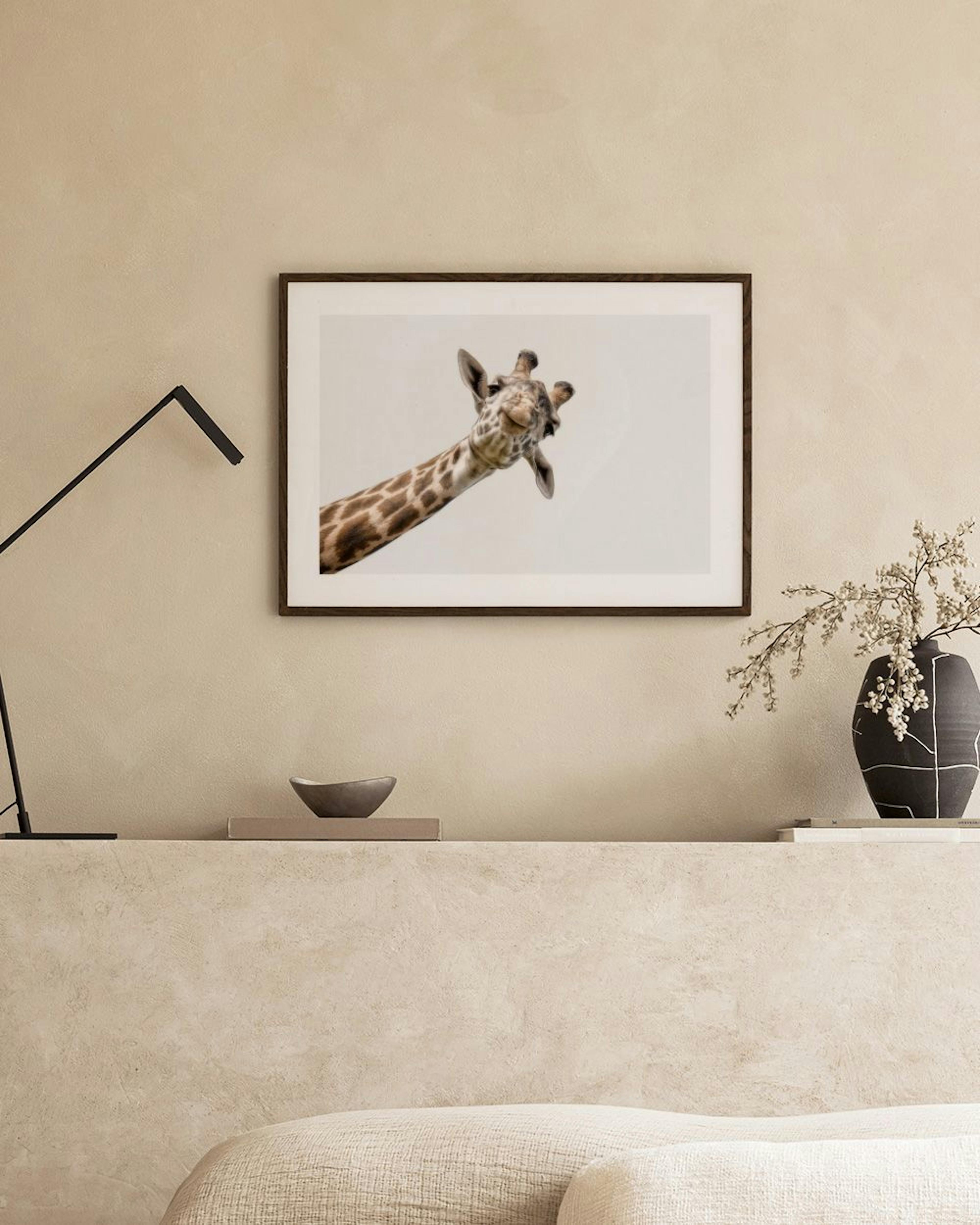 A print of a curious giraffe peeking down, displayed above a black shelf with books and hourglasses.