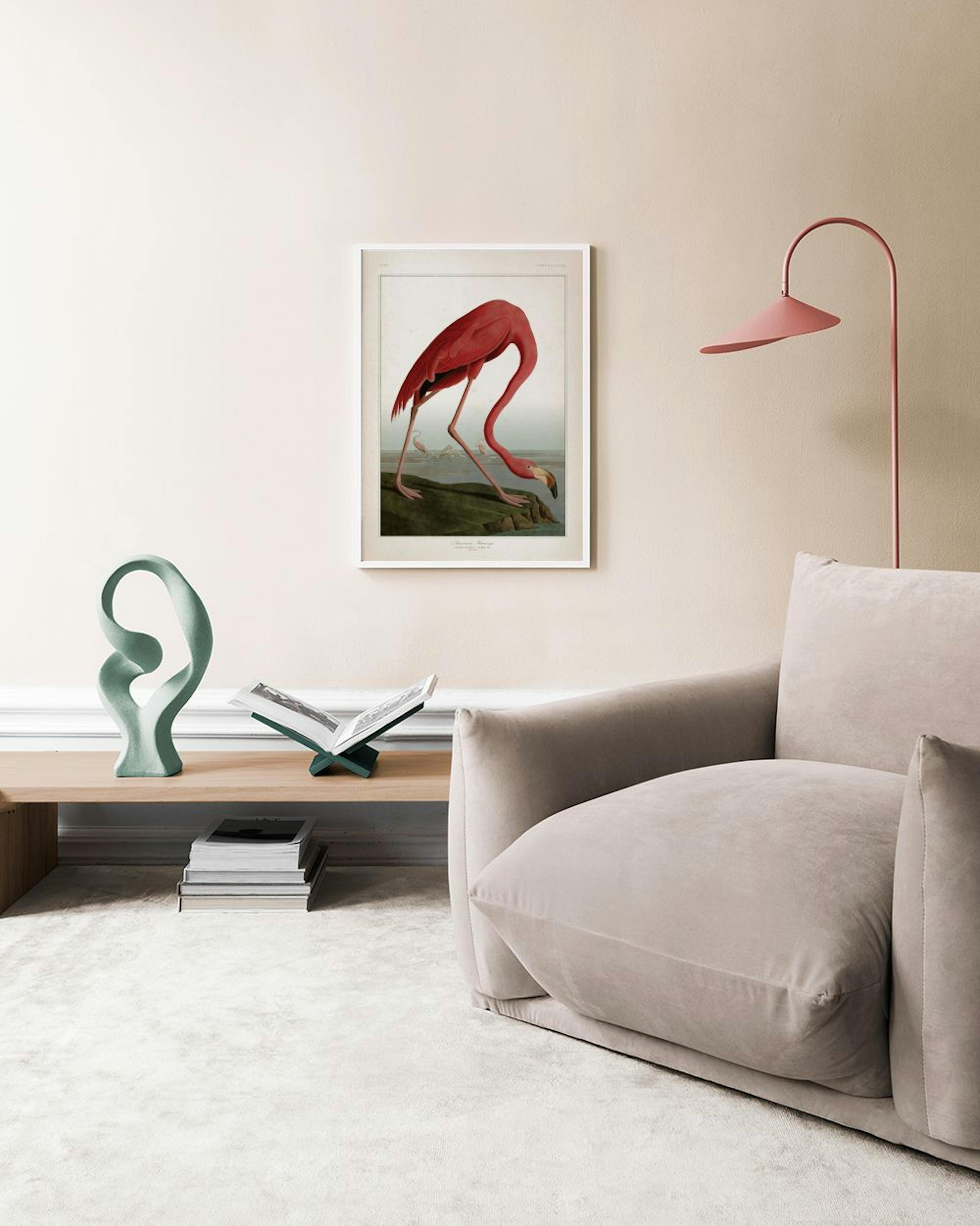 A vintage-style print of a pink flamingo drinking from water, hanging above a white console table in a living room.