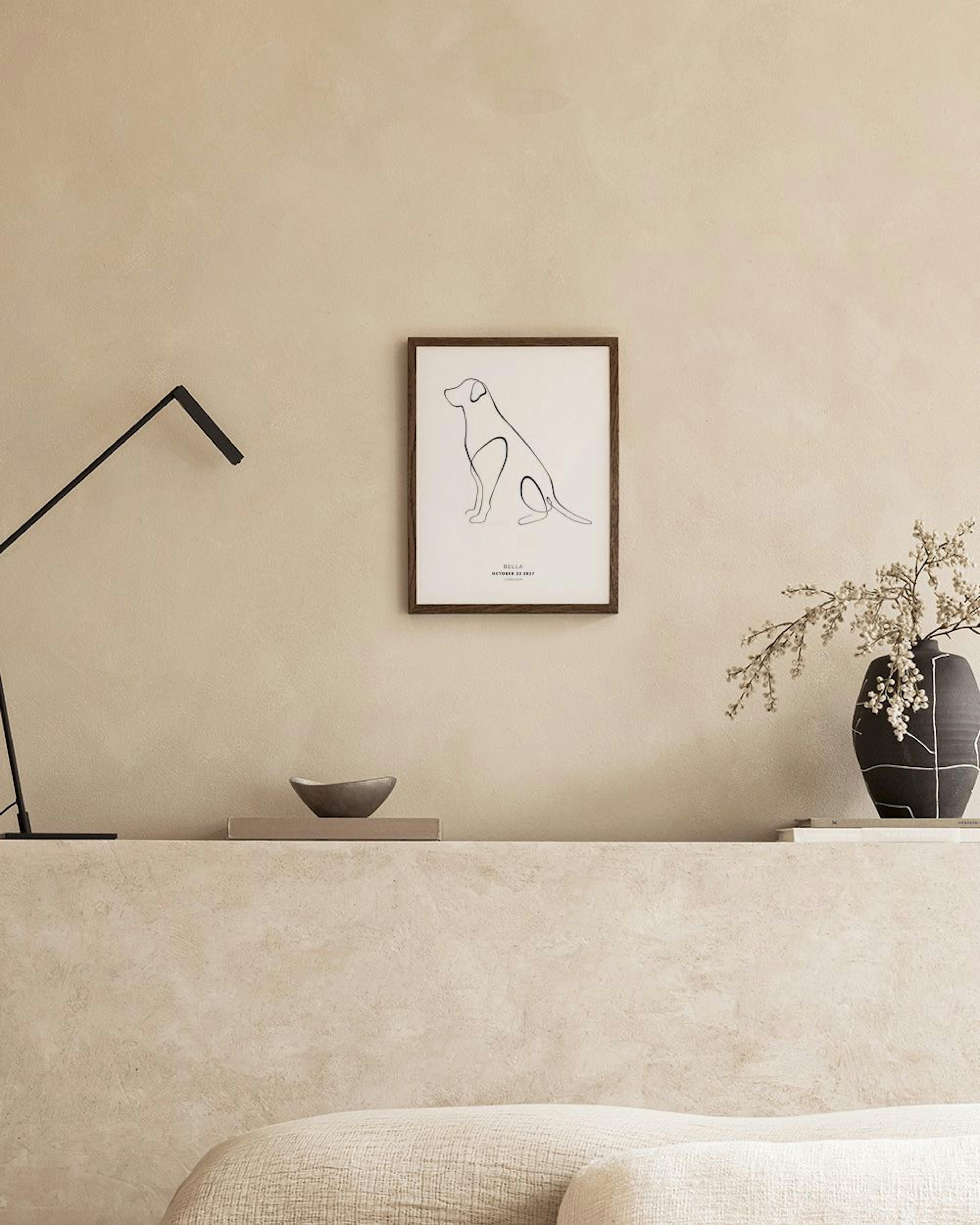 Poster personalizzato con disegno stilizzato di un cane, appeso sopra una credenza in rattan in un ambiente luminoso.