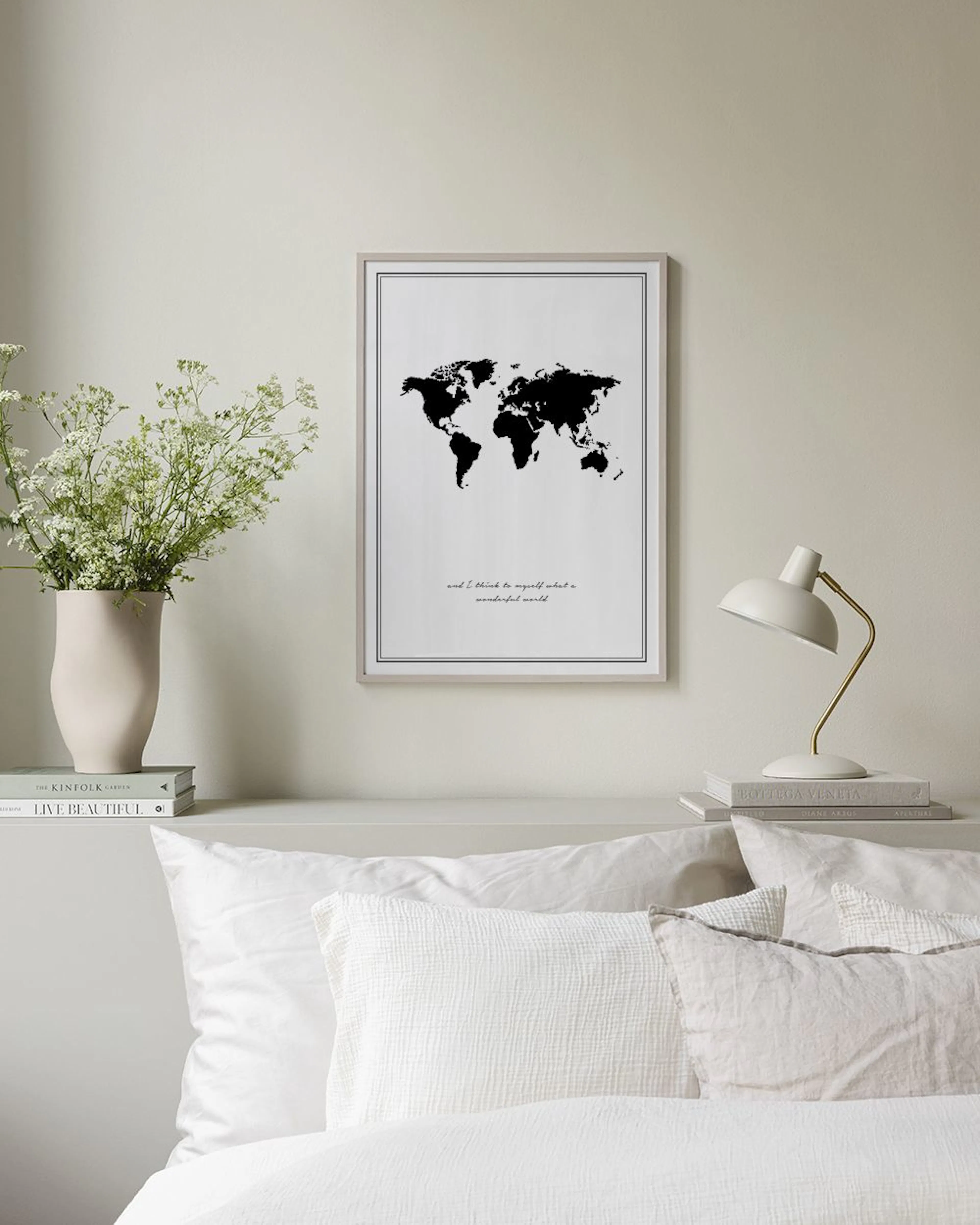 Poster med svart världskarta och texten and I think to myself what a wonderful world, upphängd på en svart gallervägg i ett rum 