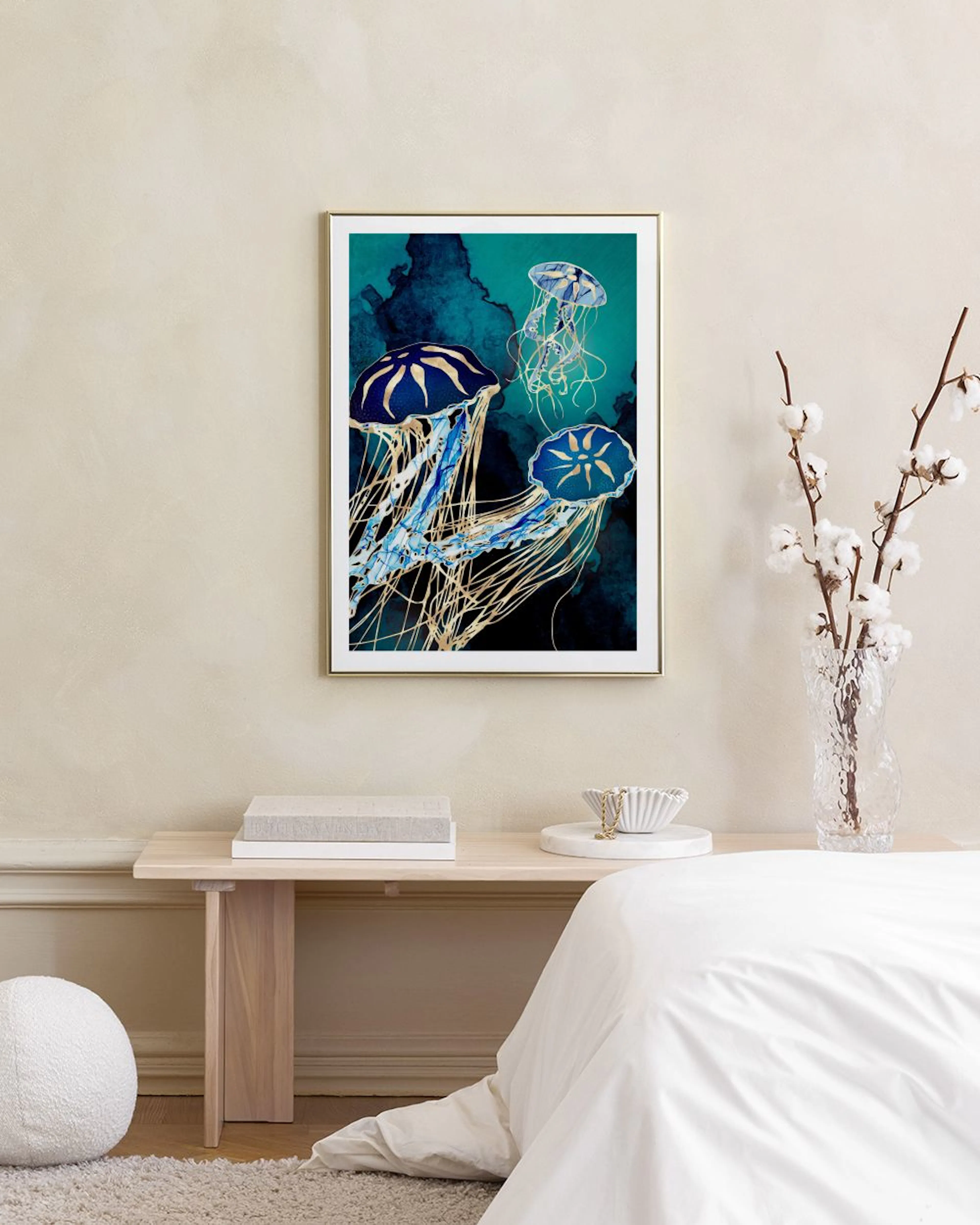 A print of blue and gold jellyfish with flowing tentacles on a dark teal background, displayed in a modern living room.