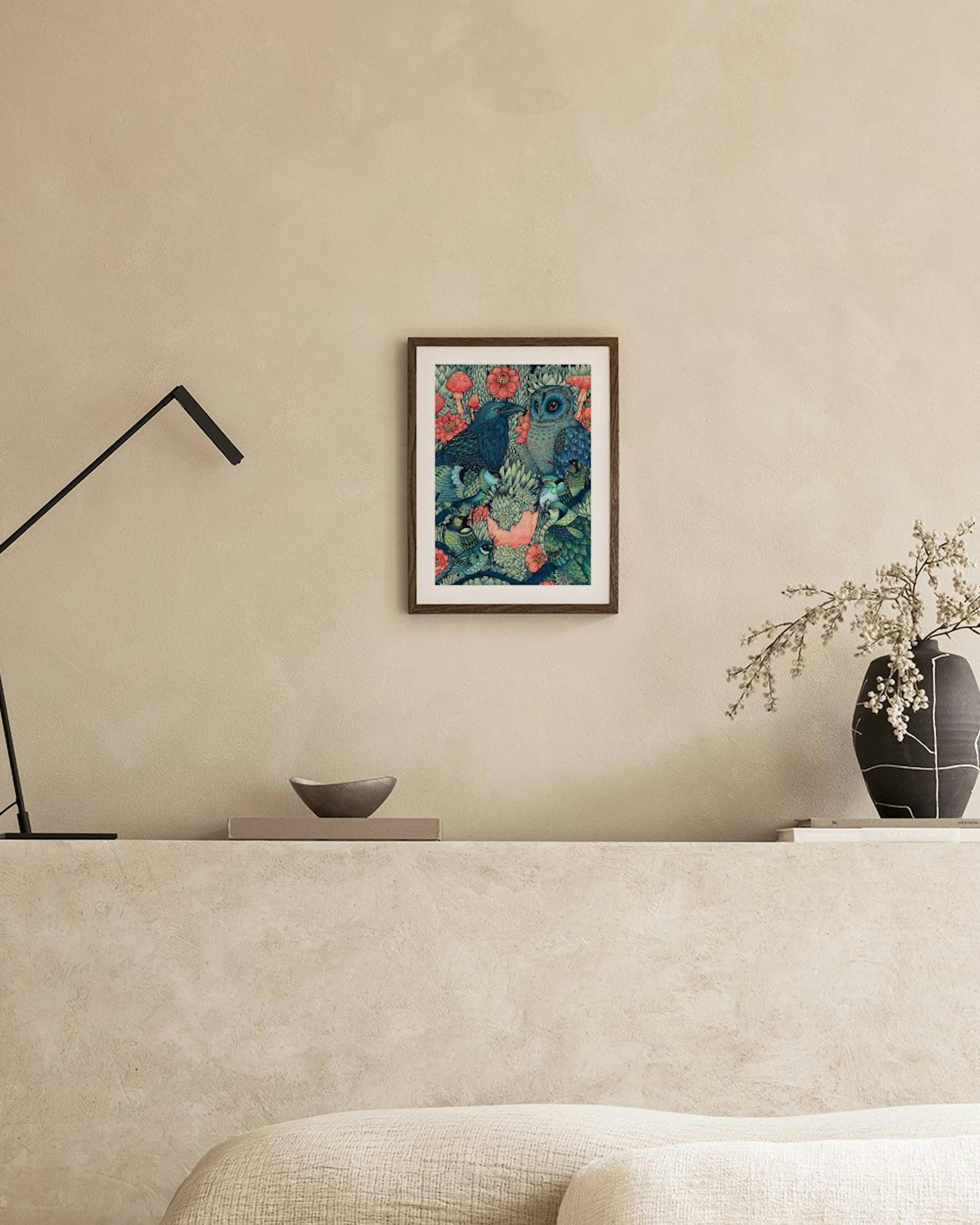 Plakat med illustration af en ravn og en ugle omgivet af svampe og blomster i mørke farver, hængende på en mørkegrøn væg i et mo