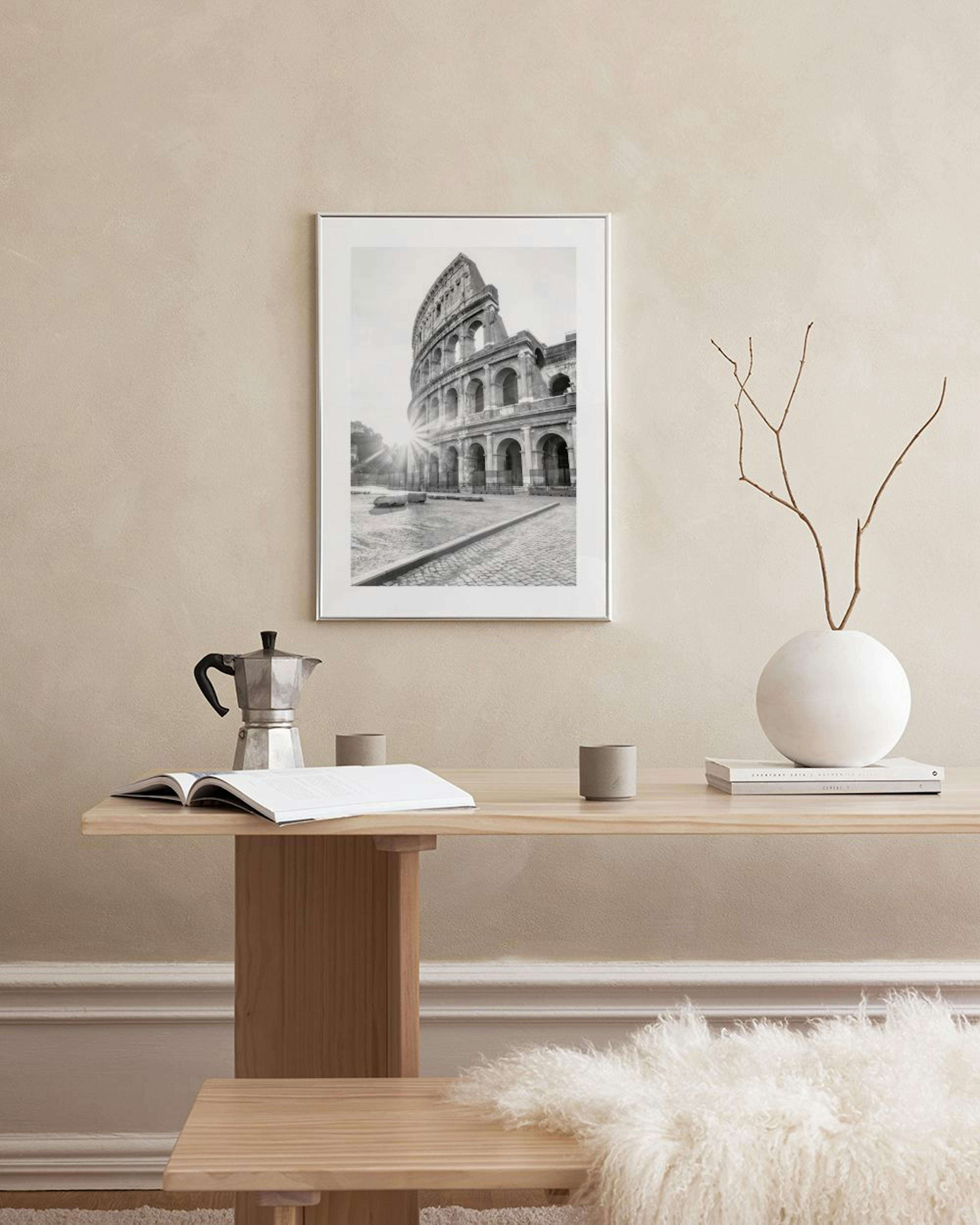Affiche du Colisée de Rome en noir et blanc, avec un soleil éclatant, suspendue au-dessus dune commode blanche avec un vase et u