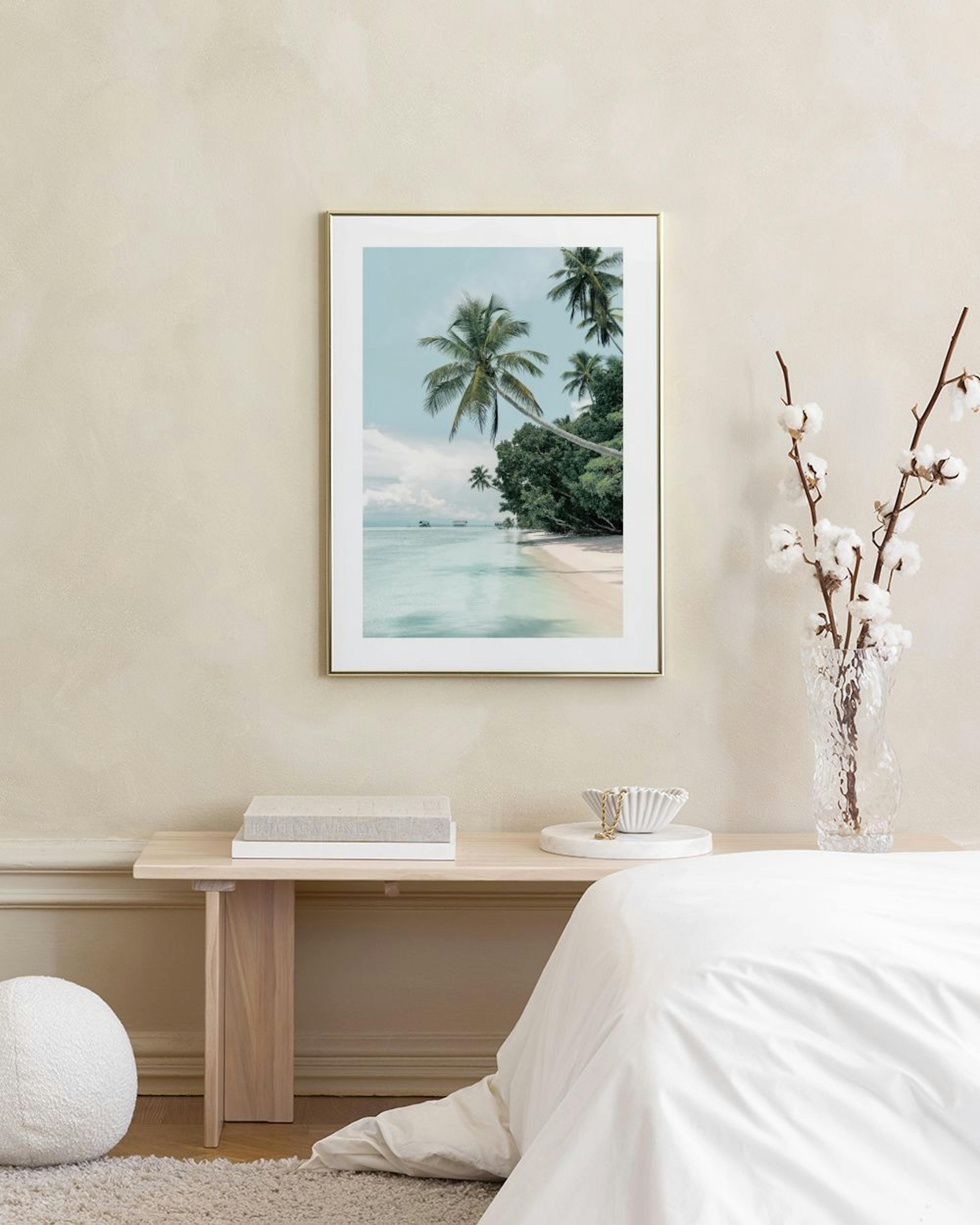 Affiche de plage tropicale avec palmiers et eau turquoise, accrochée au-dessus dun meuble en rotin clair dans un salon.