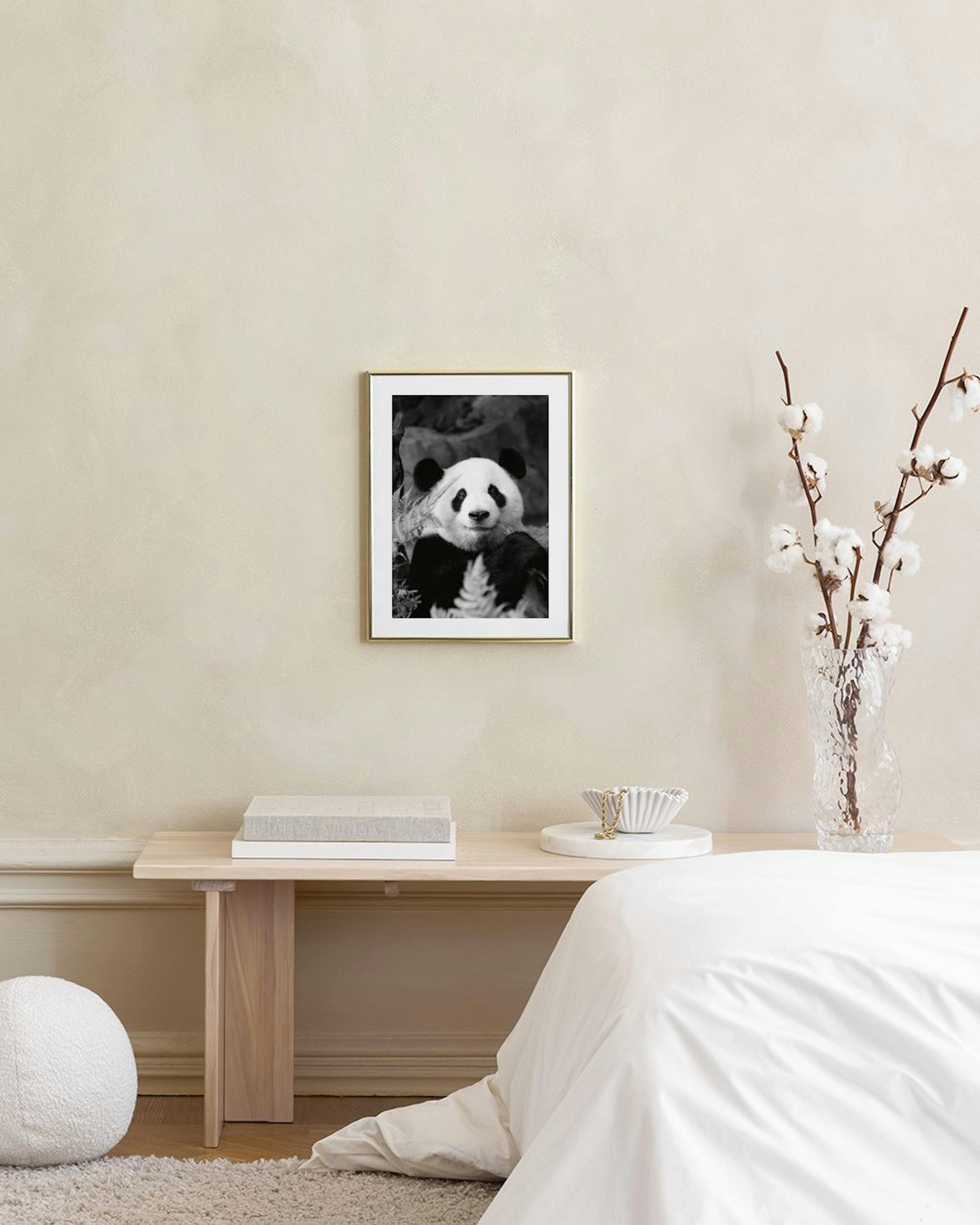 Affiche en noir et blanc dun panda au regard direct, suspendue au-dessus dun buffet noir.