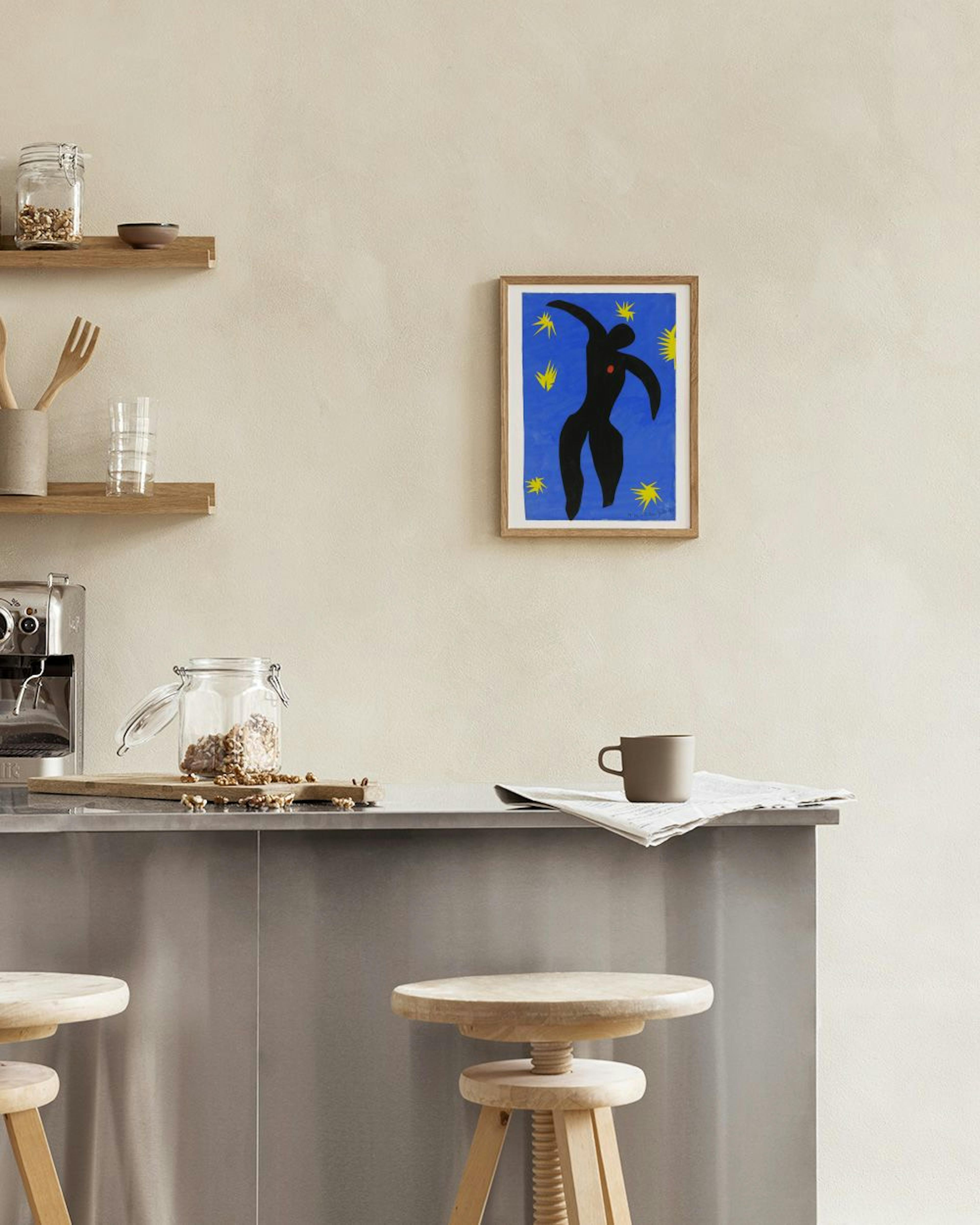 Affiche bleue avec une silhouette noire dansante et des étoiles jaunes, accrochée au-dessus dun fauteuil beige.