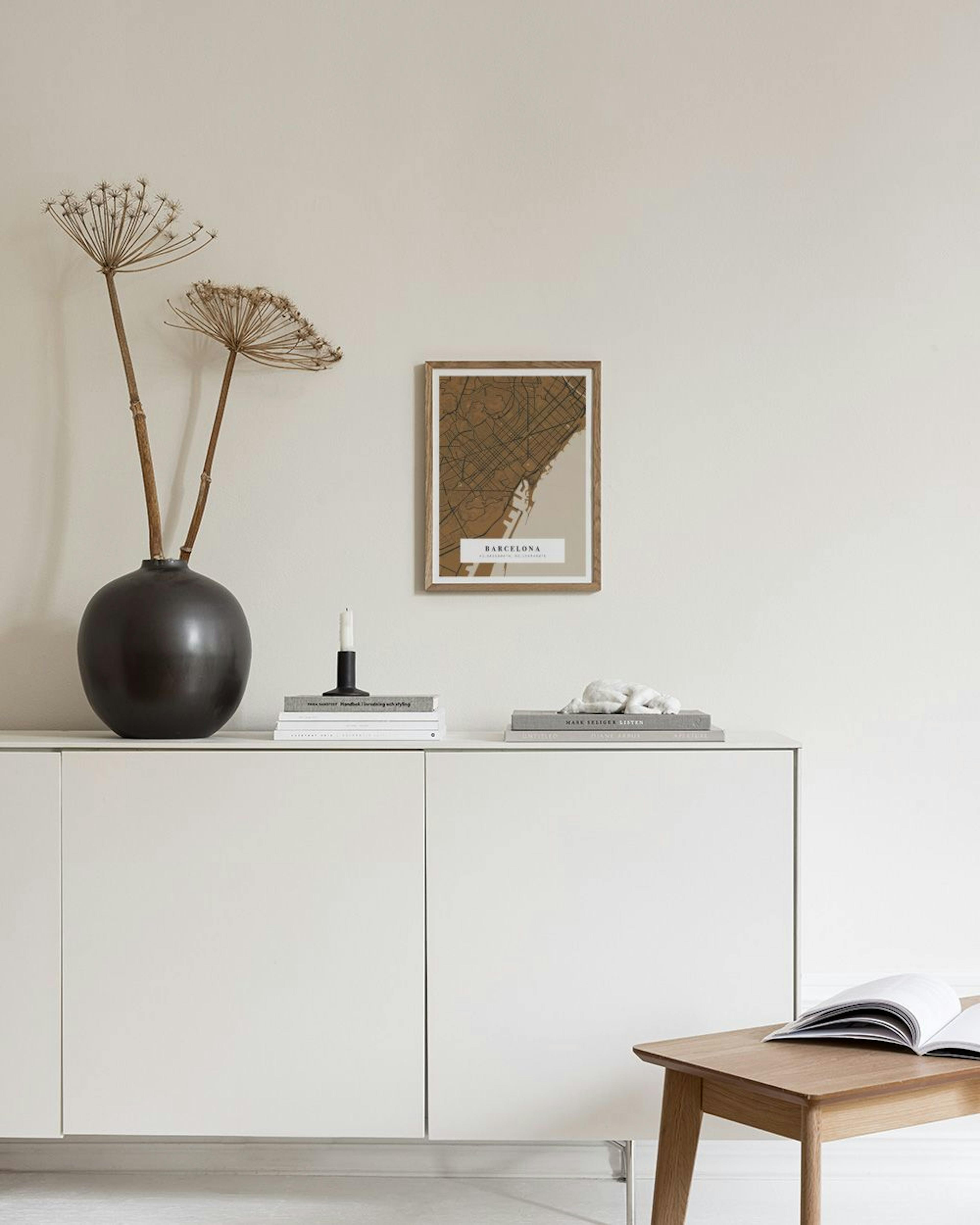Personalisiertes Poster einer Barcelona-Karte in Braun- und Beigetönen, hängend über einem weißen Sideboard mit Vasen.