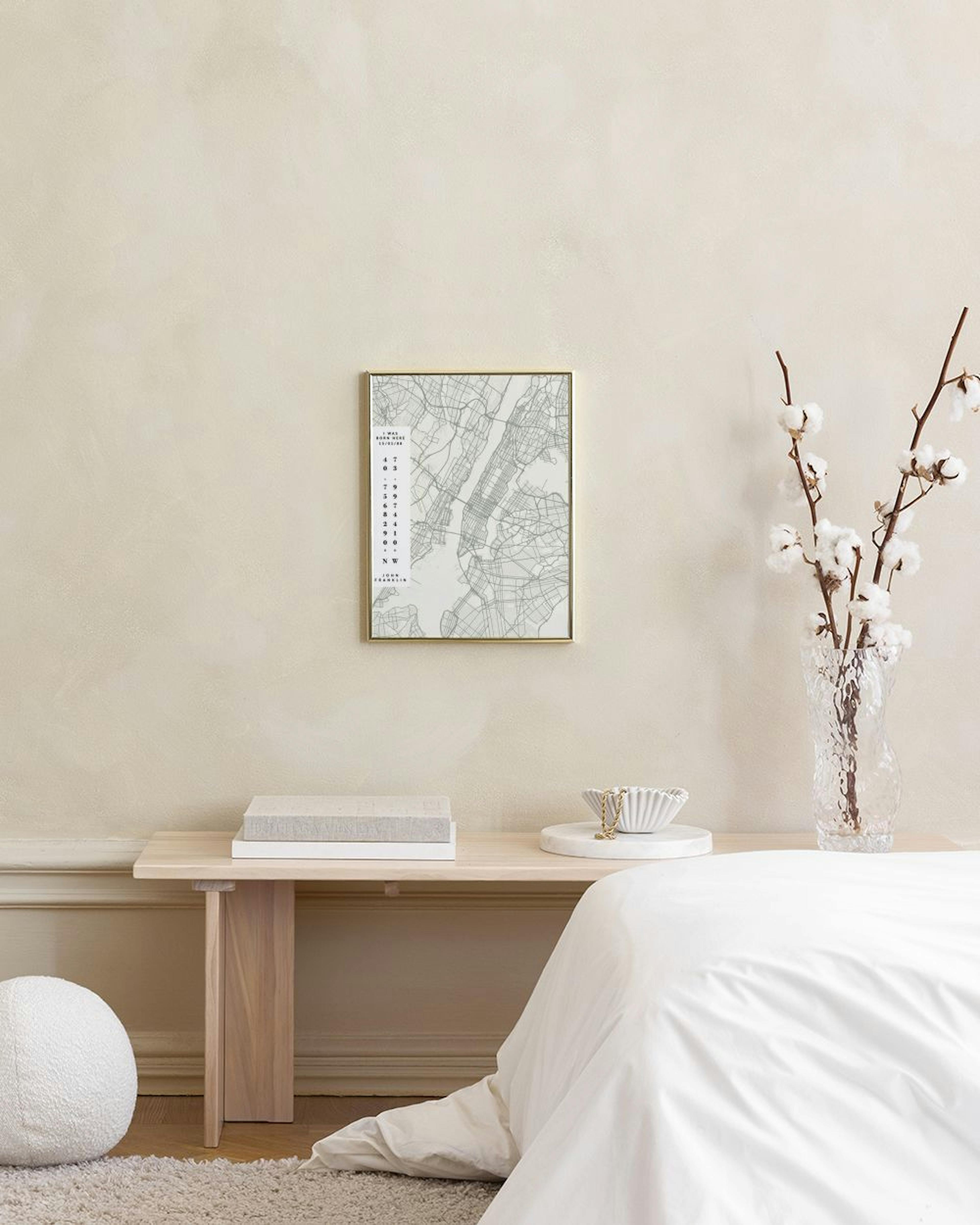 Affiche personnalisée représentant une carte de ville grise avec des coordonnées et une date, accrochée au-dessus dune table bla