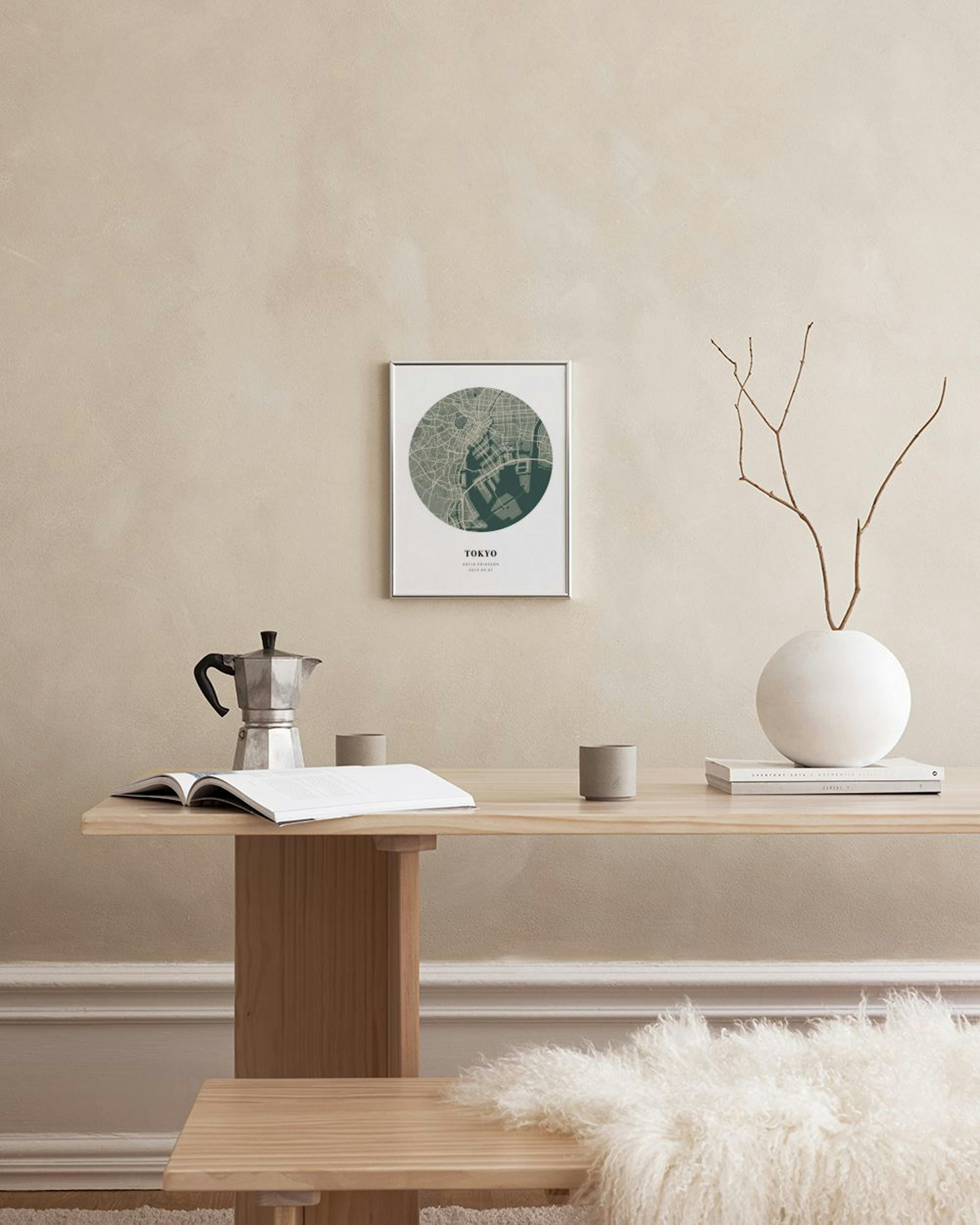 Gepersonaliseerde poster van een ronde kaart van Tokyo, hangend boven een donkergrijze dressoir met boeken en decoratie.