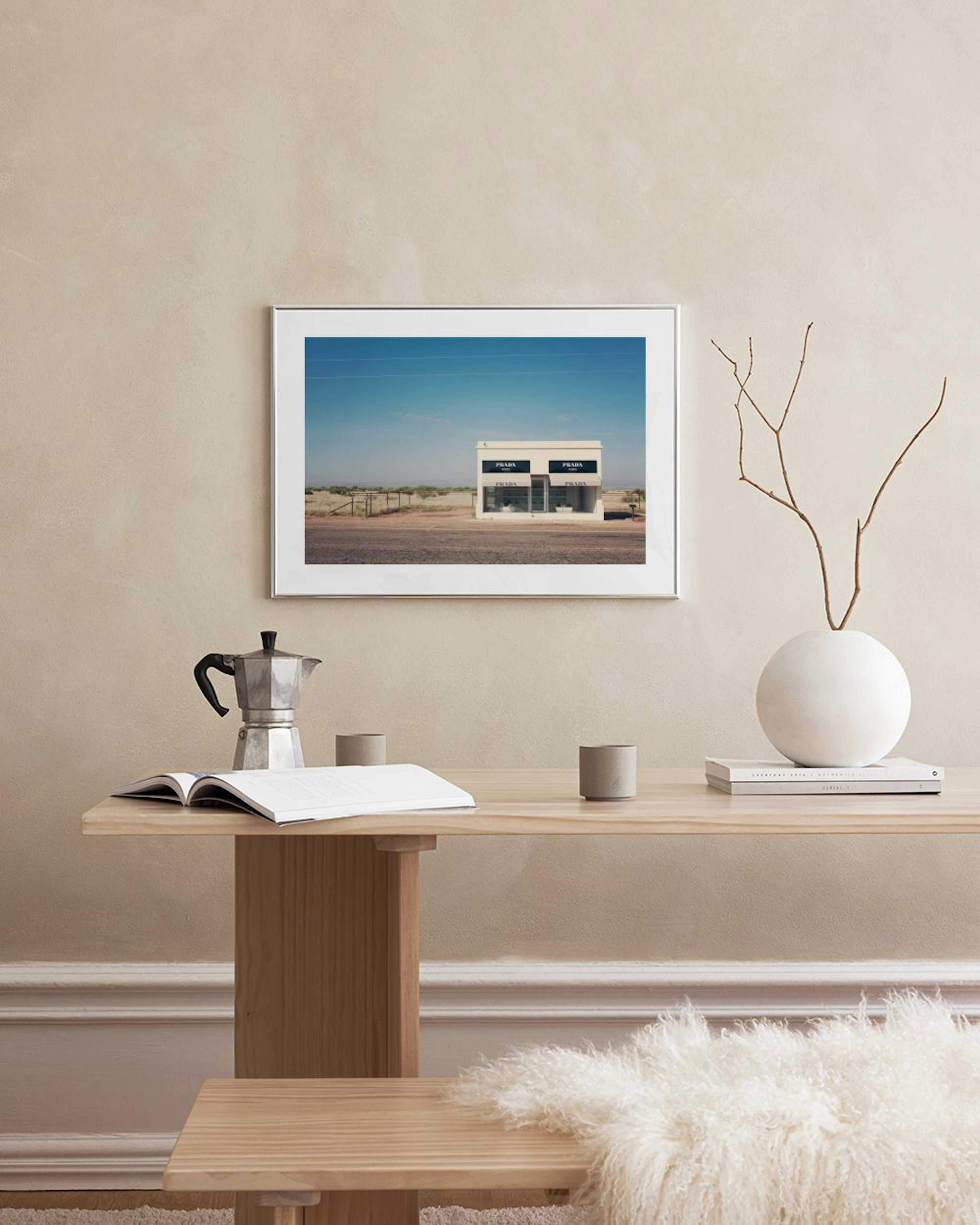 Poster con edificio Prada Marfa nel deserto, appeso su parete bianca in soggiorno moderno con poltrona in pelle.