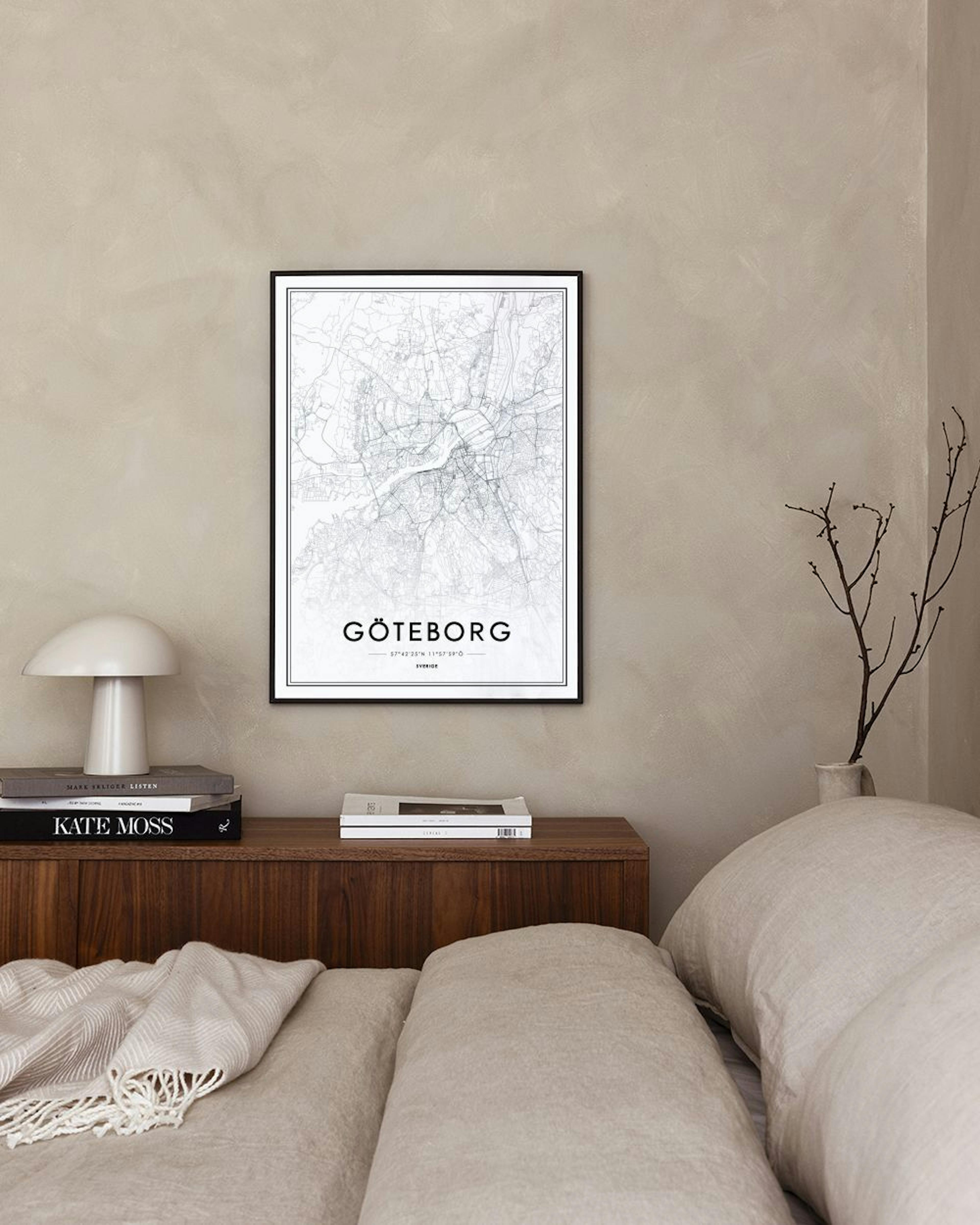 Een poster met een gedetailleerde kaart van Göteborg, hangend aan een donkerblauwe muur naast een witte stoel.